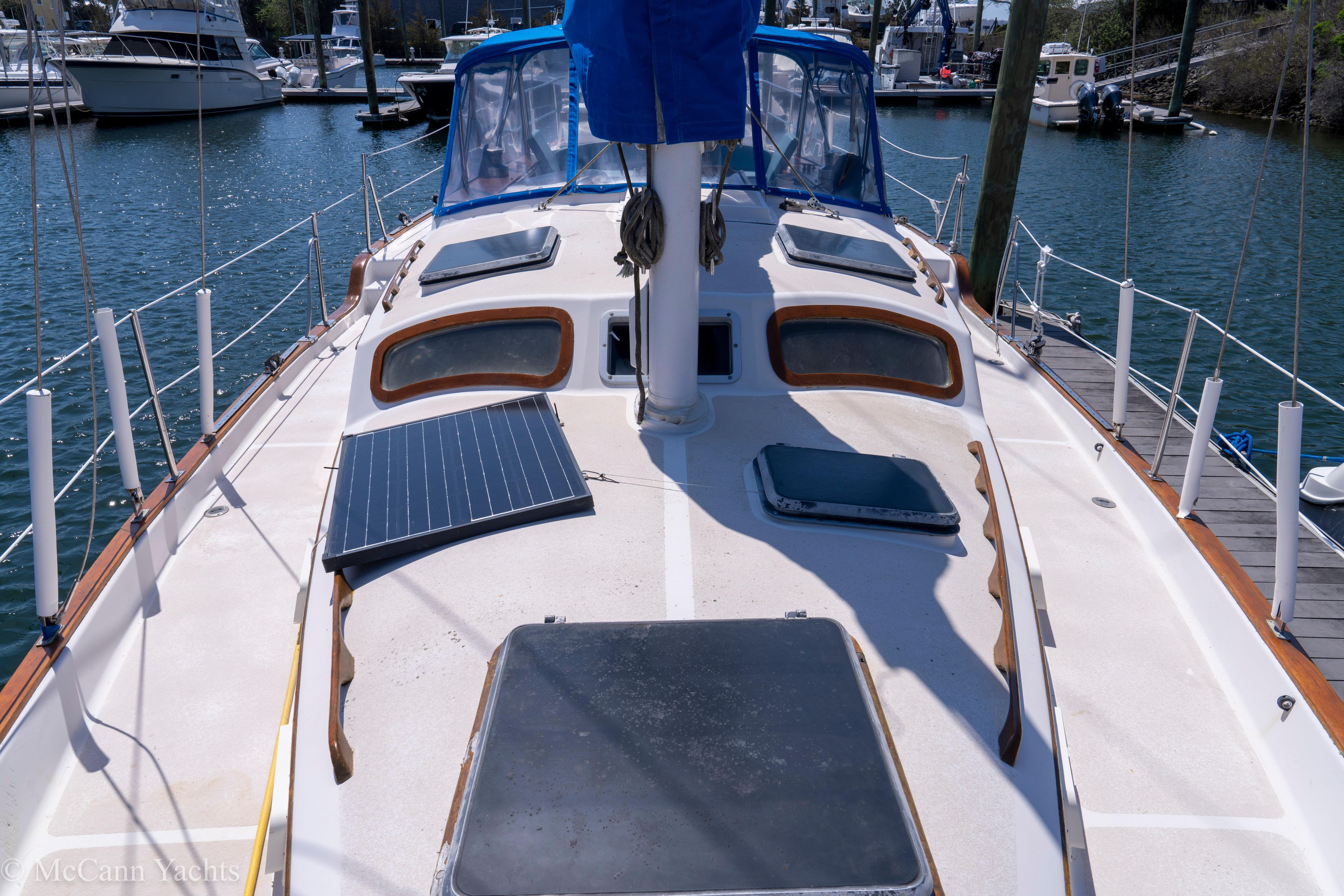 1980 Irwin 46 sailboat deck with solar panels, docked in a marina.