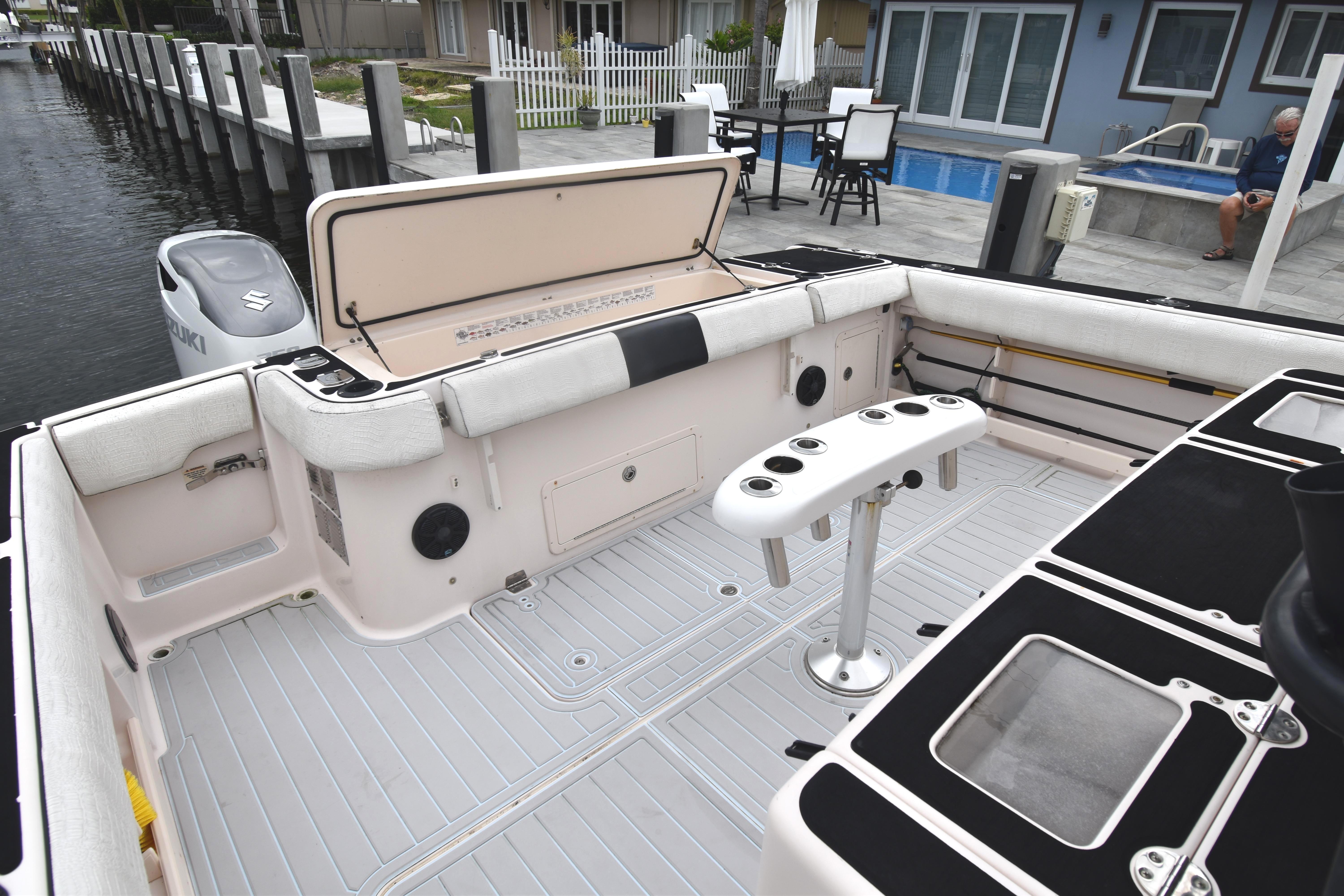 2010 Grady-White Canyon 366 boat deck with seating and rod holders, docked by waterfront homes.
