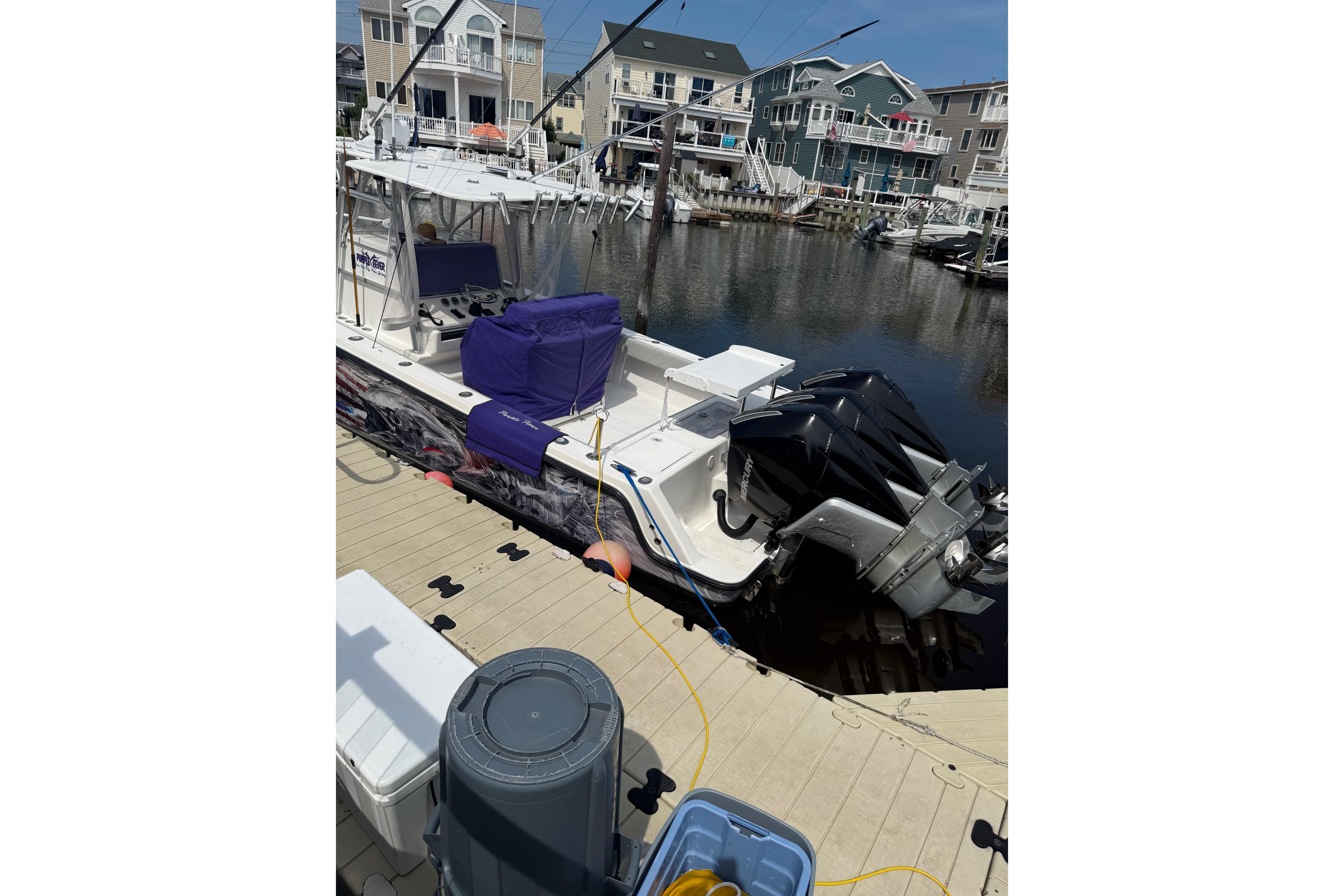 2006 SeaVee 340B boat docked, featuring dual outboard engines and covered seating.