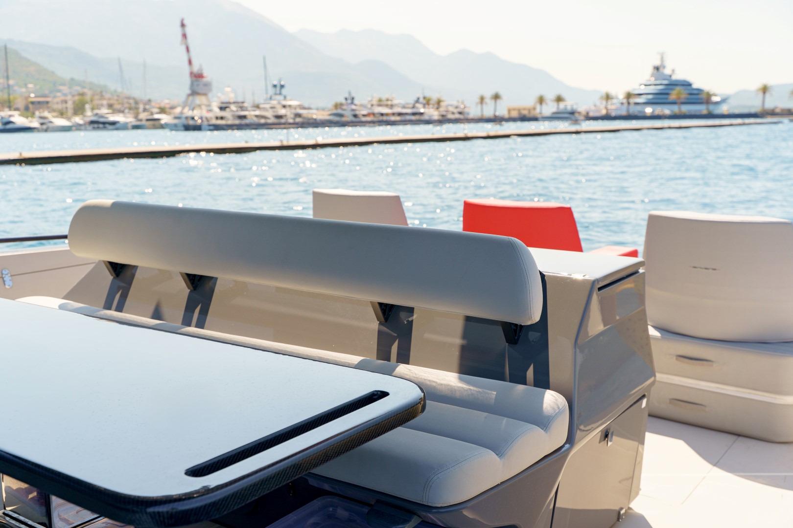 2023 Anvera 48 yacht interior with seating and table, docked in a scenic marina.