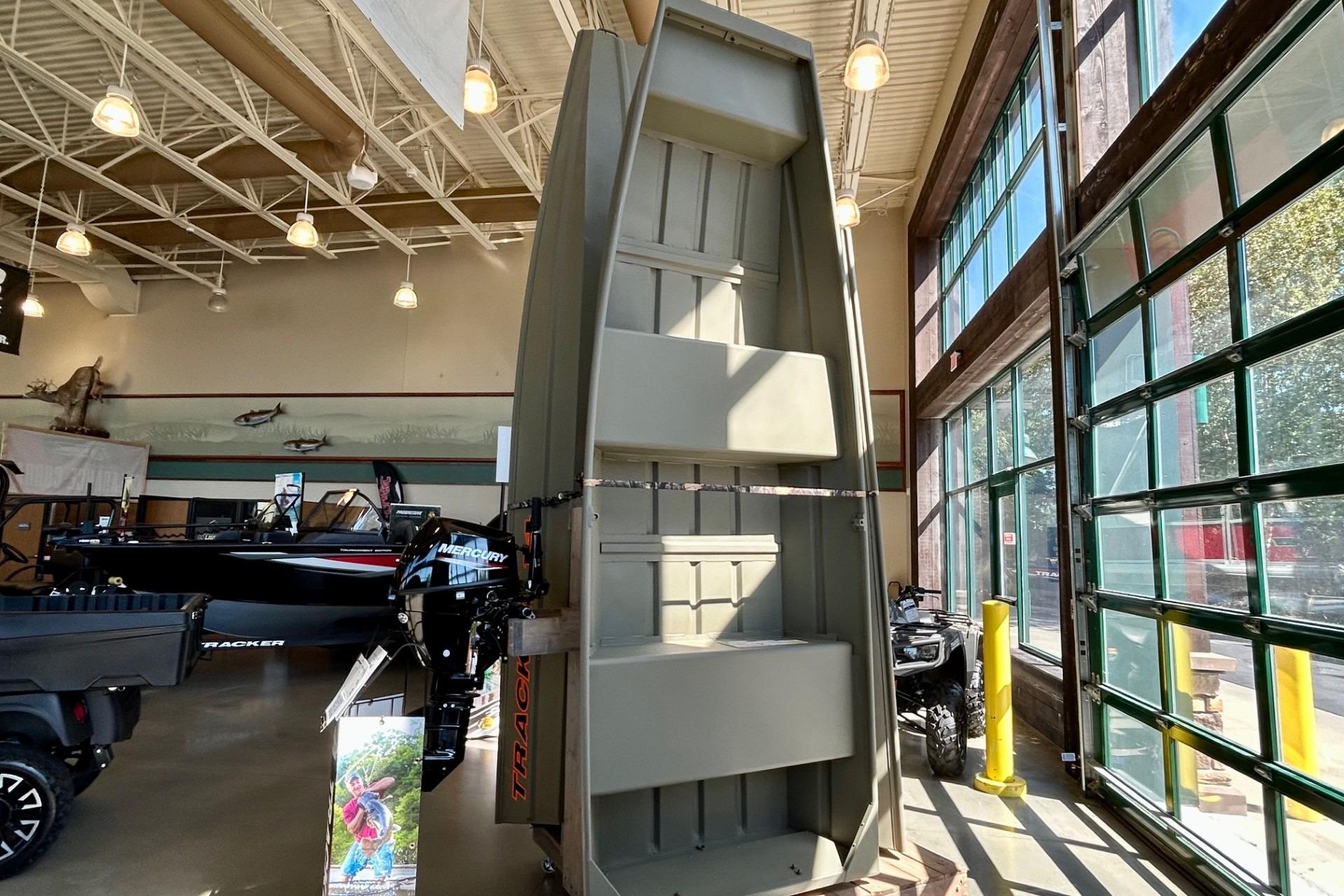 2026 Tracker Grizzly 14 Jon boat displayed in a showroom with high ceilings.