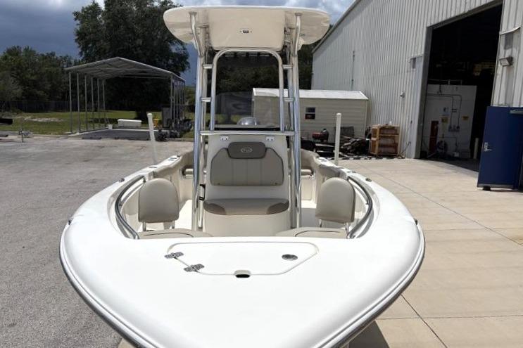 2023 Key West 203 FS boat docked near a warehouse, showcasing its sleek design.