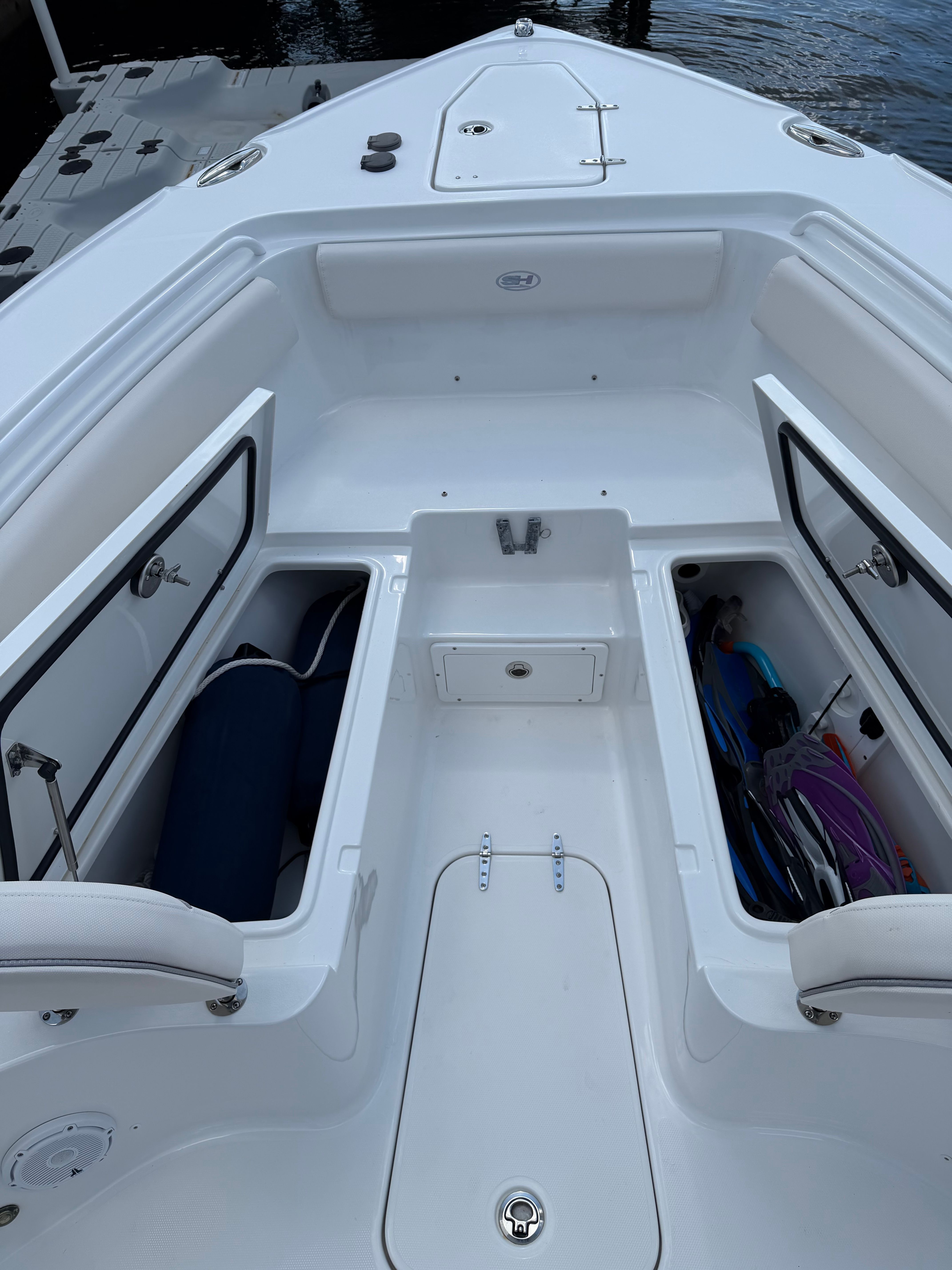 The image shows the bow of a Sea Hunt Ultra 265 SE boat with storage compartments.