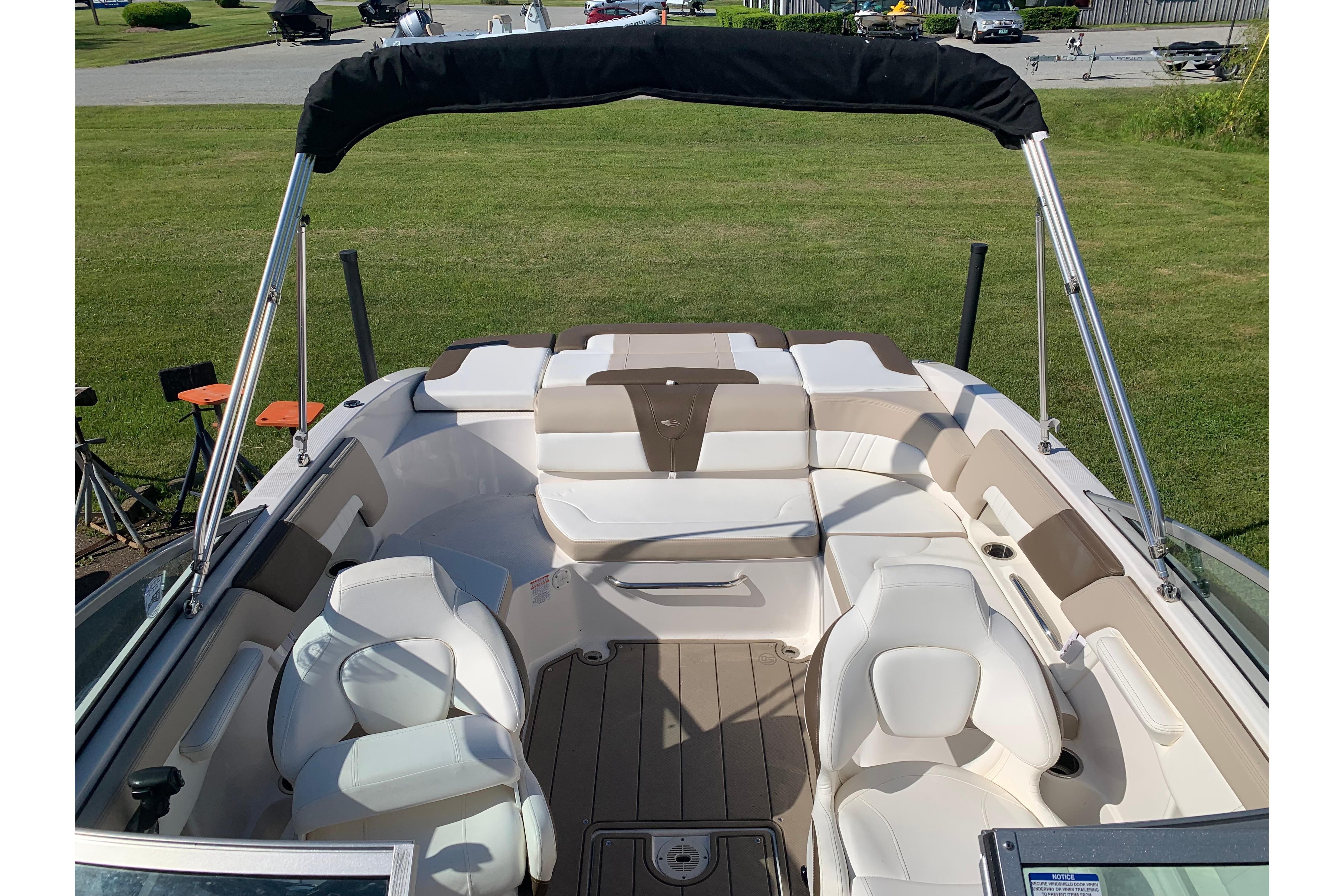 2022 Chaparral 23 SSi boat interior with beige and white seating, bimini top, and spacious layout.