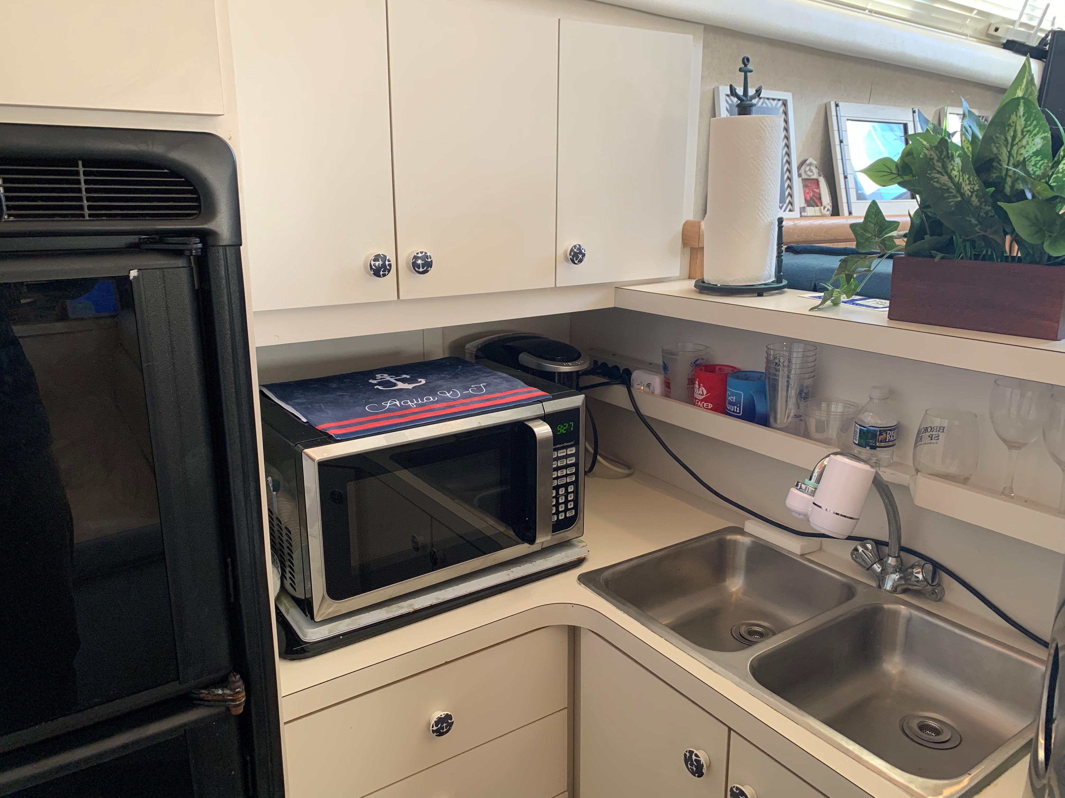 1992 Silverton 34 Aft Cabin Motor Yacht kitchen with microwave, dual sink, and storage cabinets.