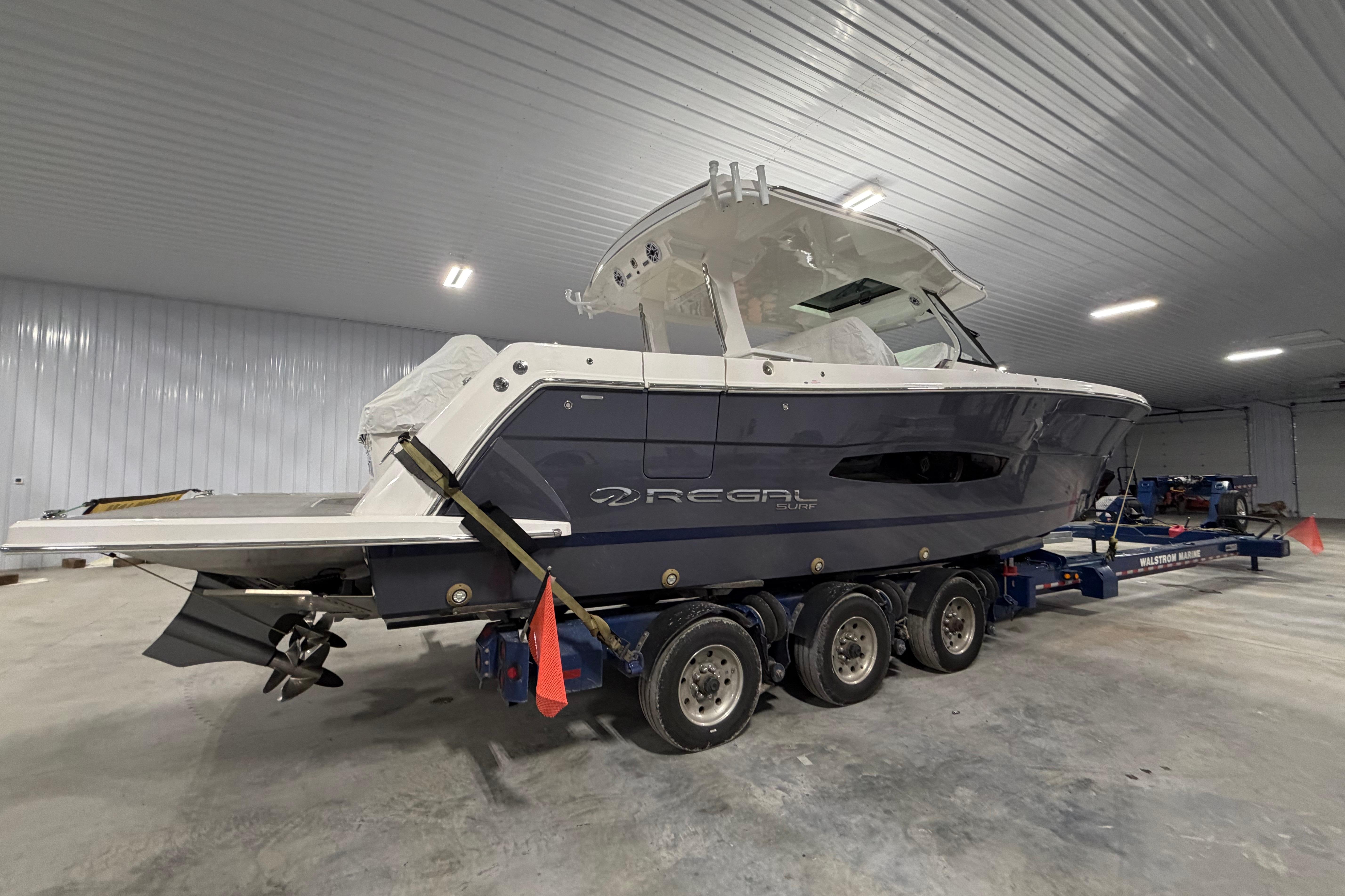 2027 Regal 38 Surf boat on trailer in indoor storage facility.