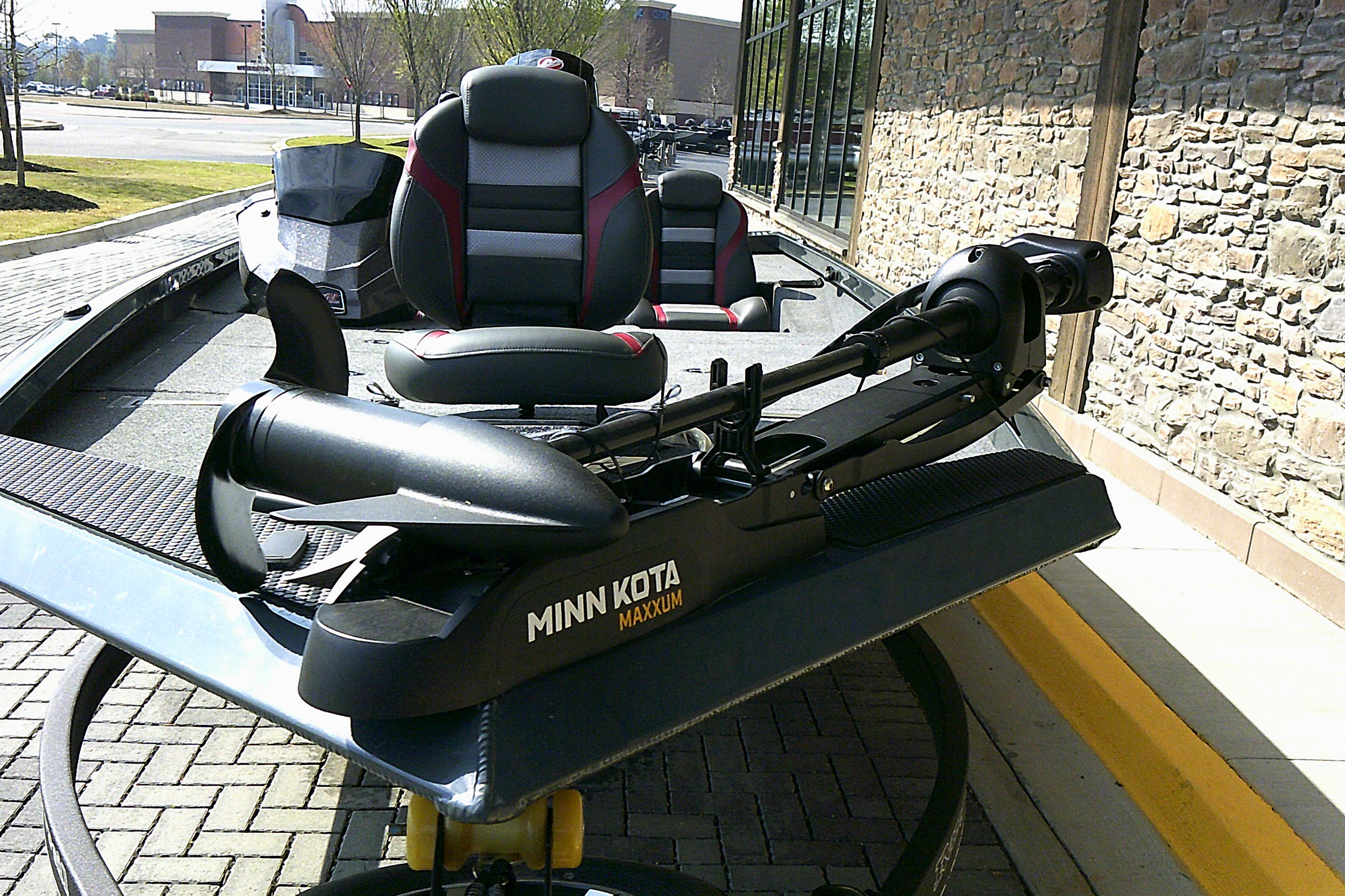2025 Ranger RT198P boat with Minn Kota Maxxum trolling motor, parked near a stone wall.