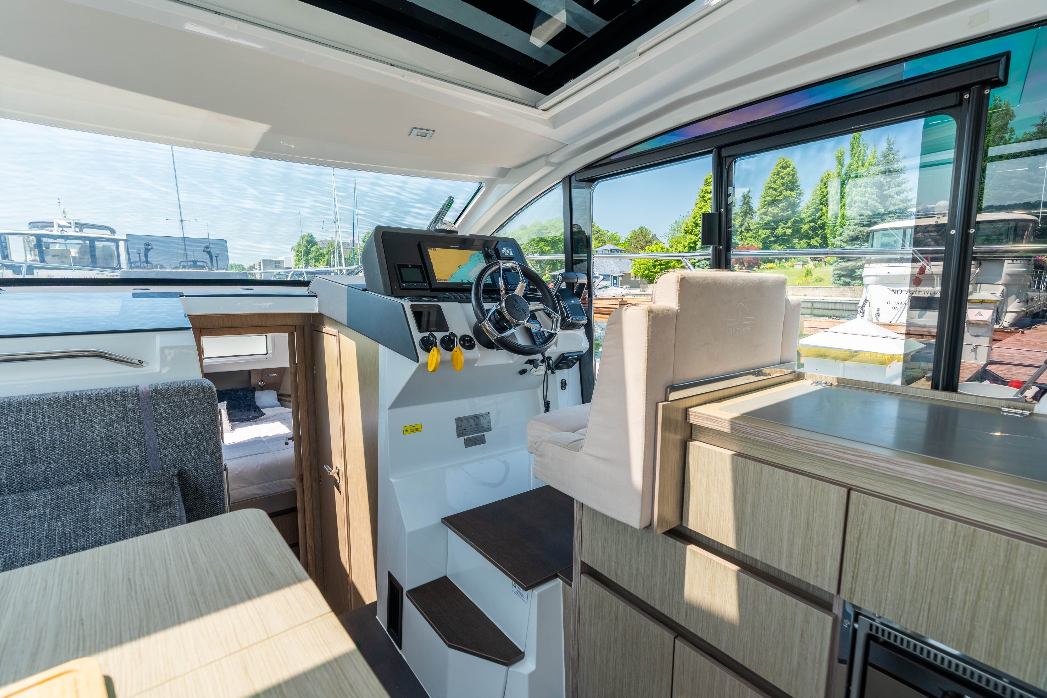 Interior of the 2023 Sealine C335V with a modern helm and comfortable seating.
