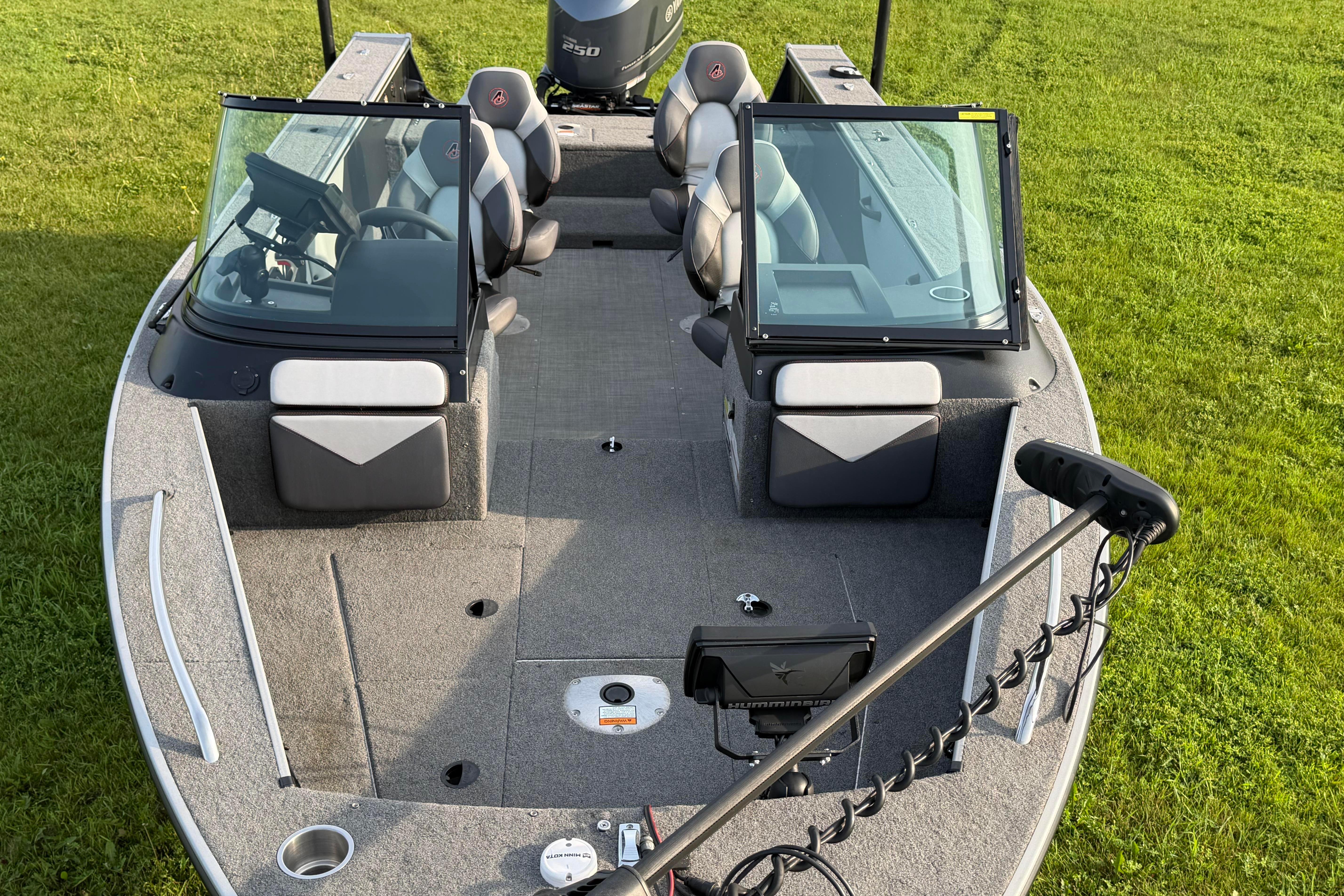 2019 Alumacraft Trophy 205 boat interior with seating and equipment on grassy background.