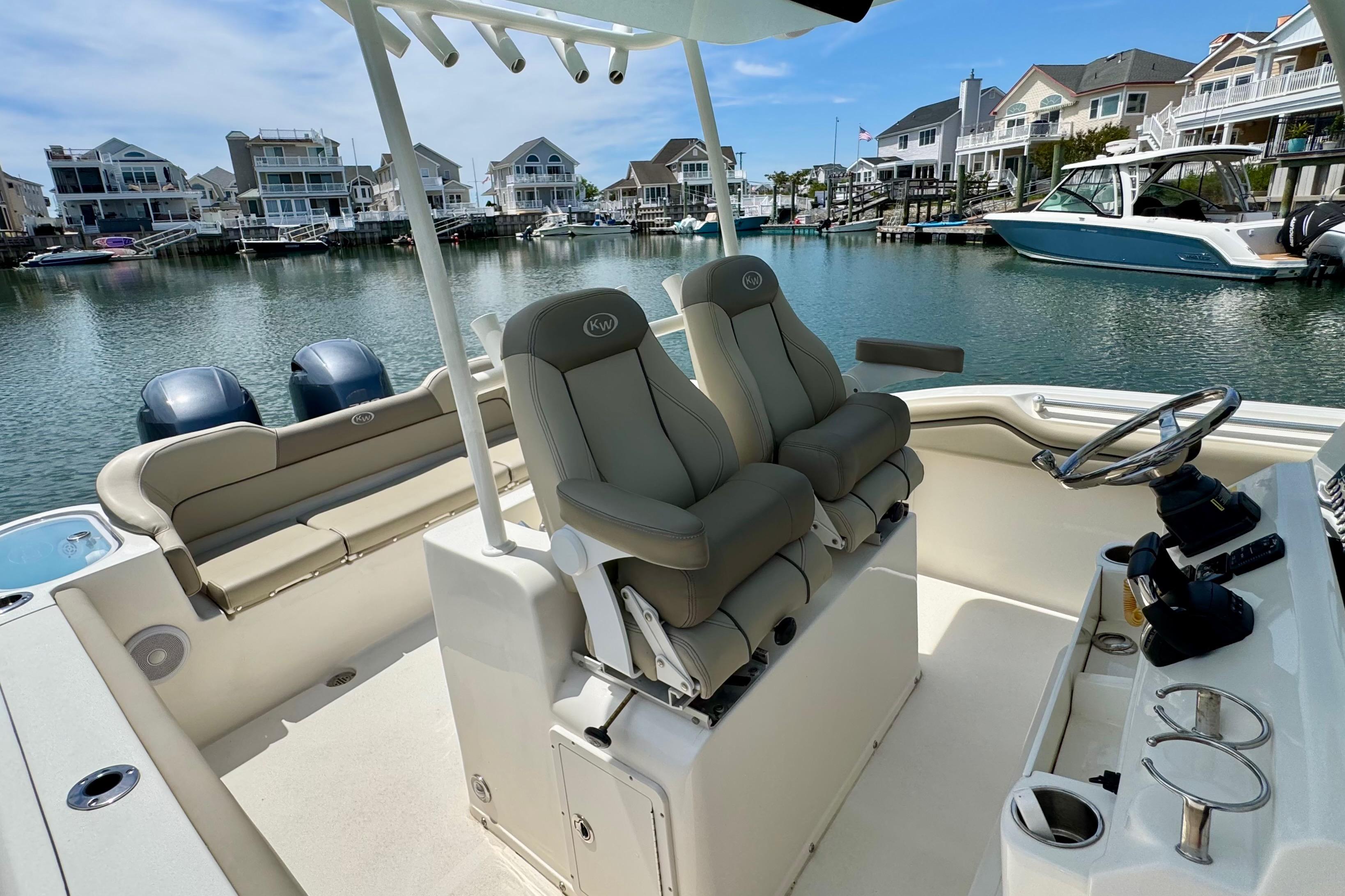 2022 Key West 263 FS boat interior with seating and steering, docked in a marina.