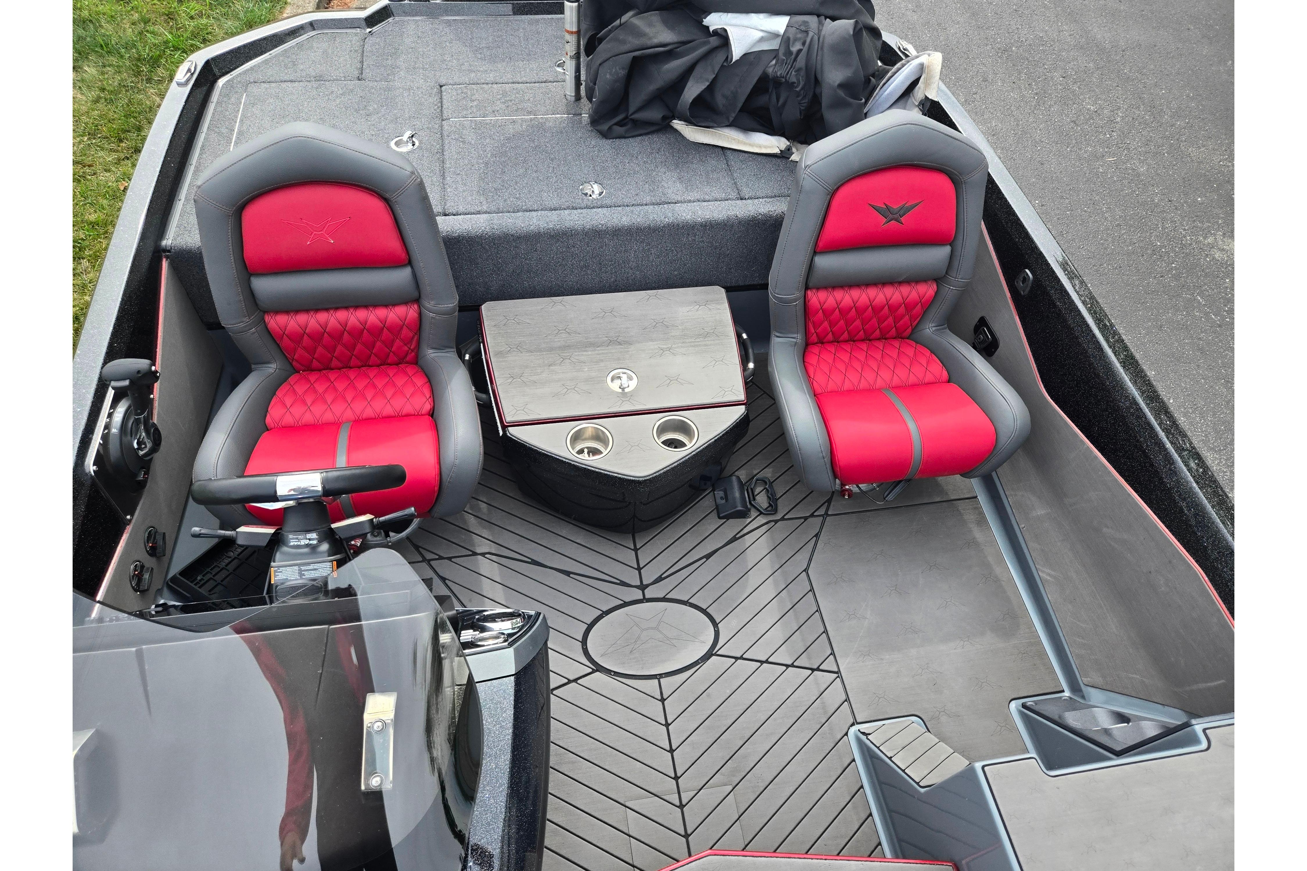 2022 Vexus VX20 boat interior with red and gray seats, steering wheel, and storage compartments.