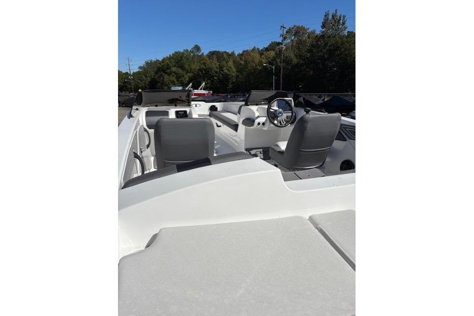 2025 Tahoe T21 boat interior with steering wheel and seating, under clear blue sky.