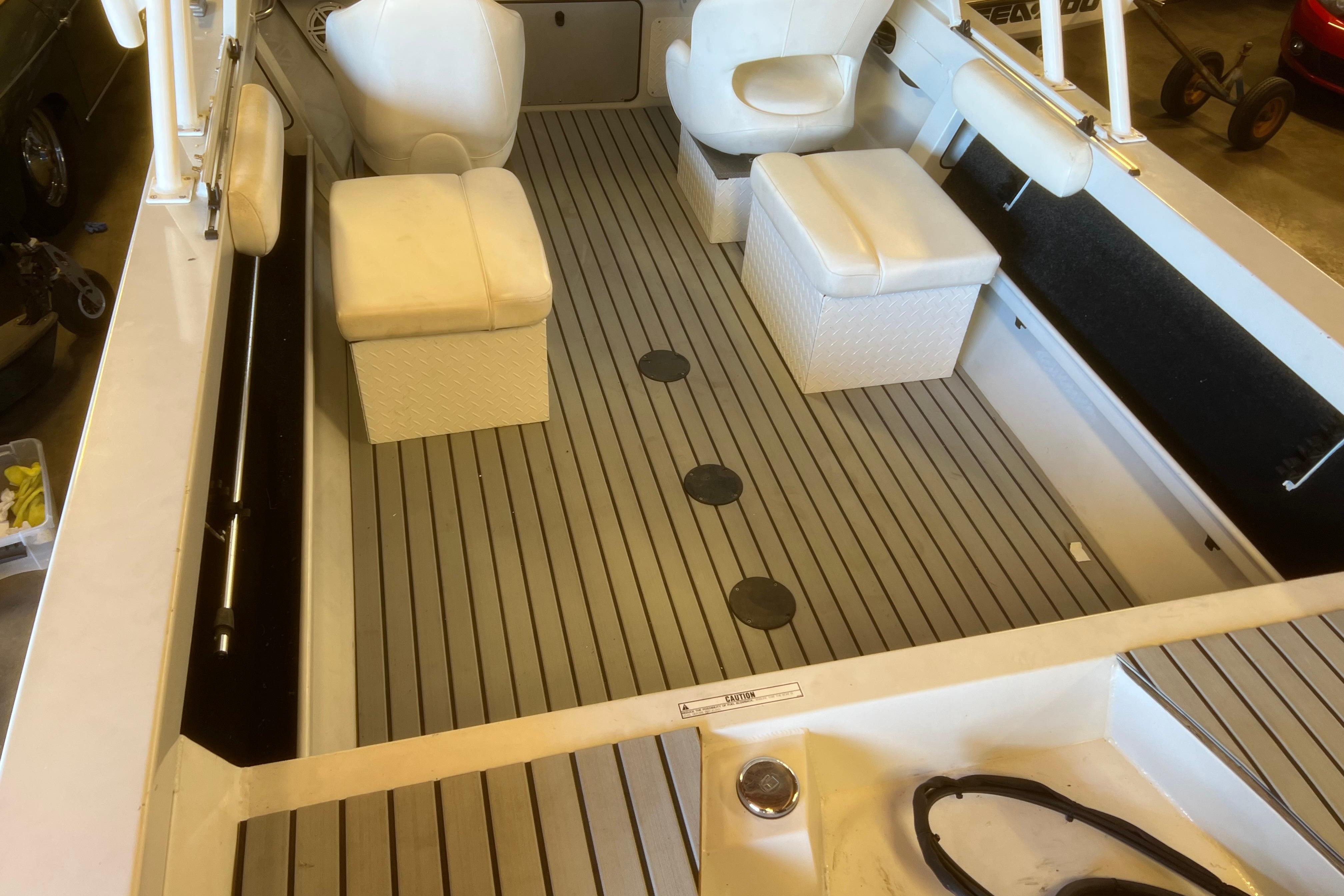 2019 KingFisher 1825 Falcon boat interior with cushioned seating and striped flooring.