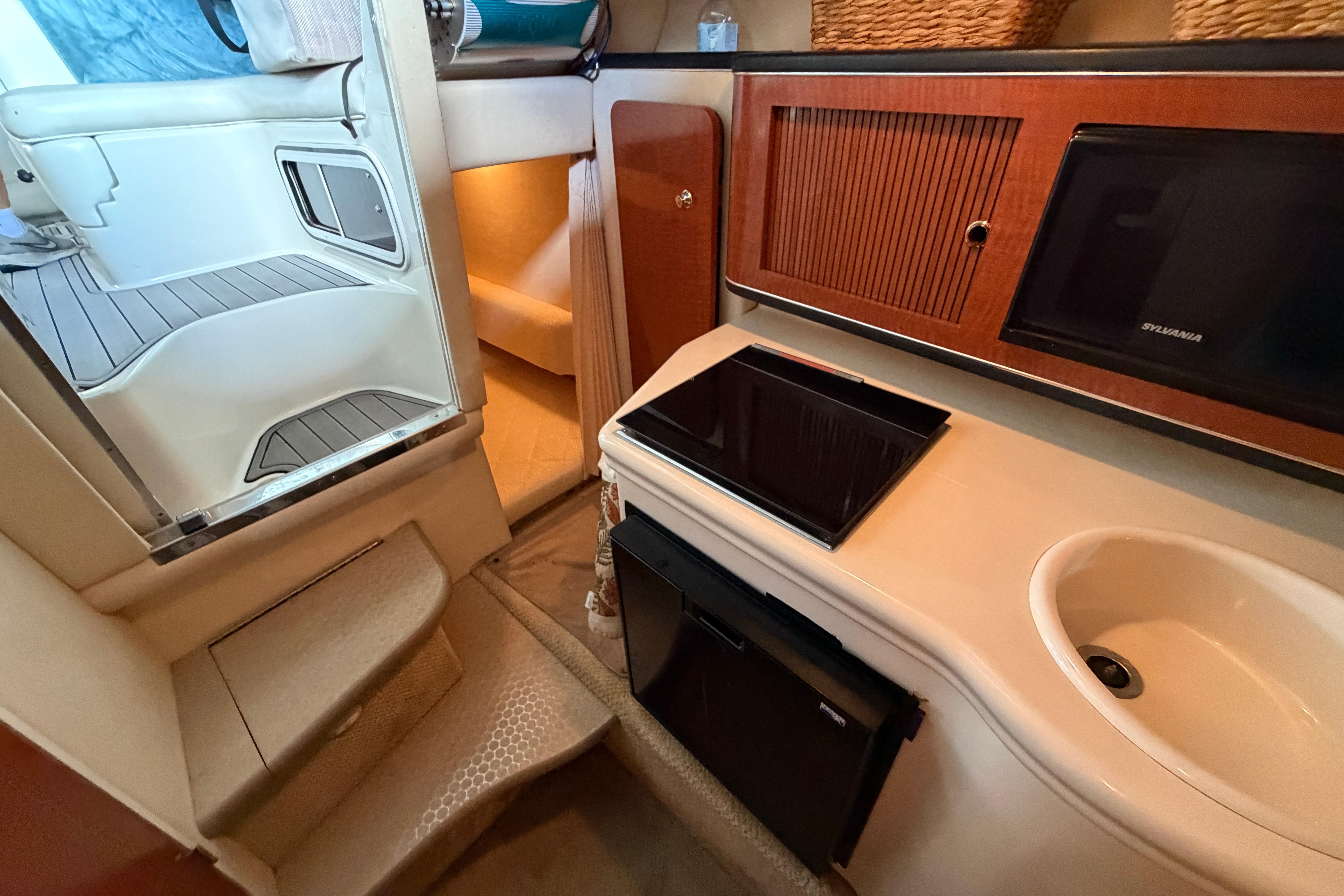 Interior of 2004 Sea Ray Sundancer 260, featuring kitchenette and seating area.