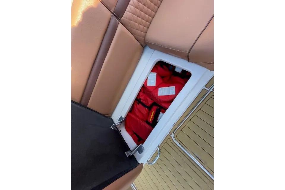 Storage compartment with life jackets on a 2016 Sea Ray Sundancer 510 boat.
