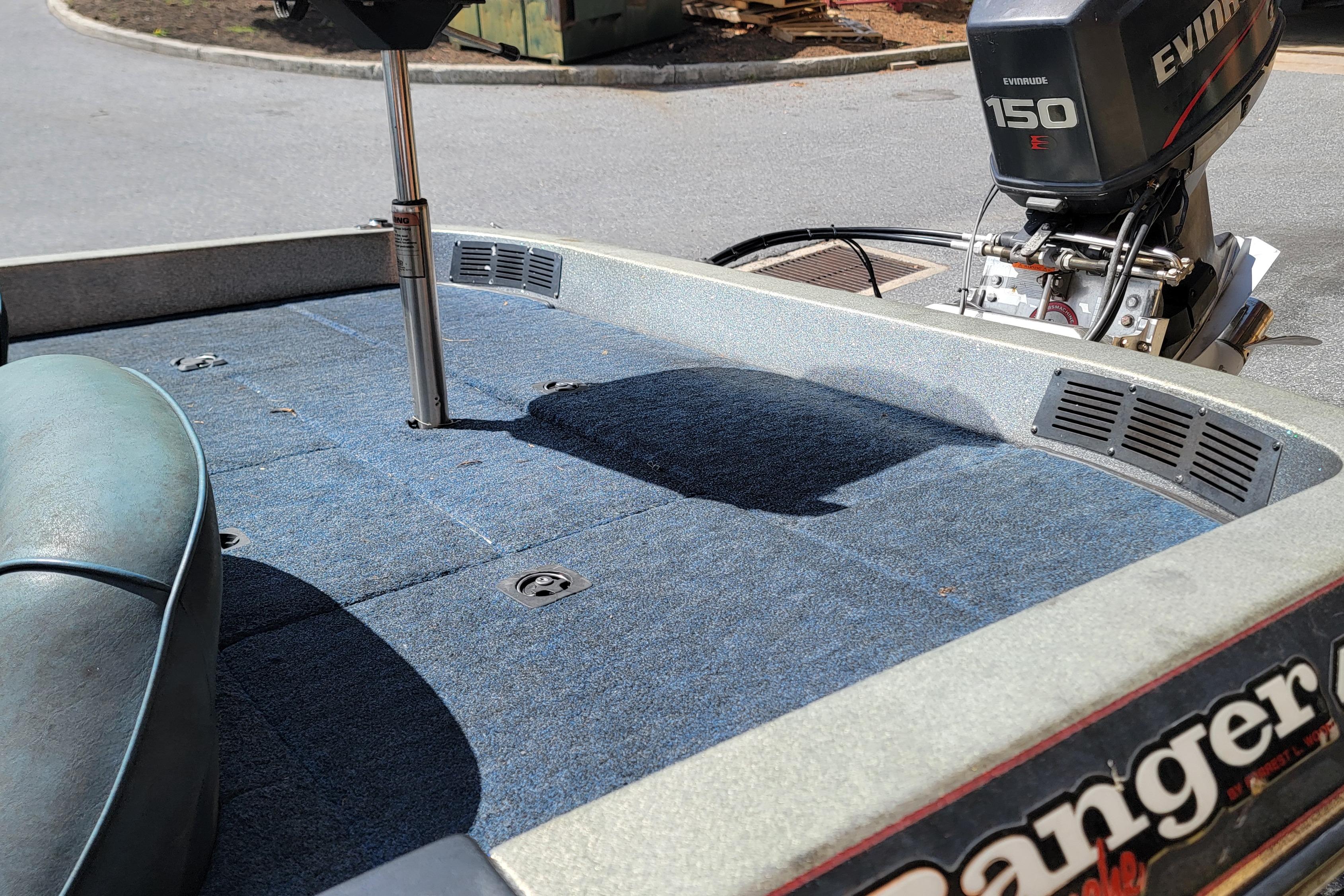 1995 Ranger boat with Evinrude 150 engine, blue carpeted deck, and seating area.