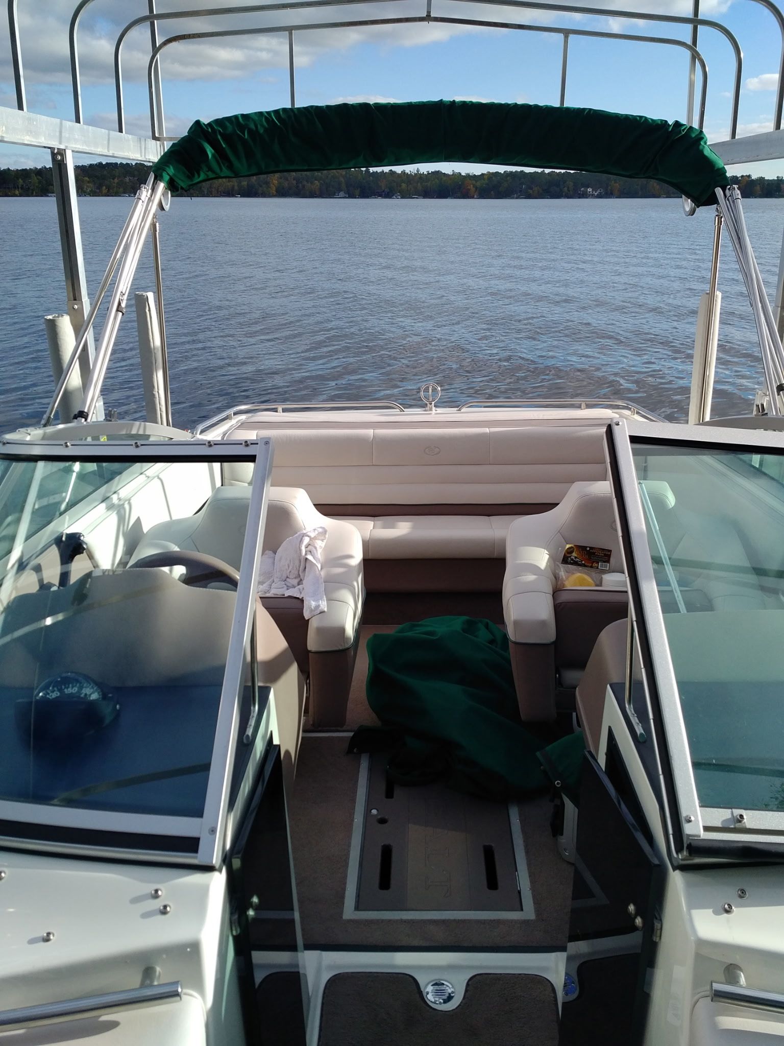 A 1995 Cobalt 222 boat on a calm lake with a green canopy.