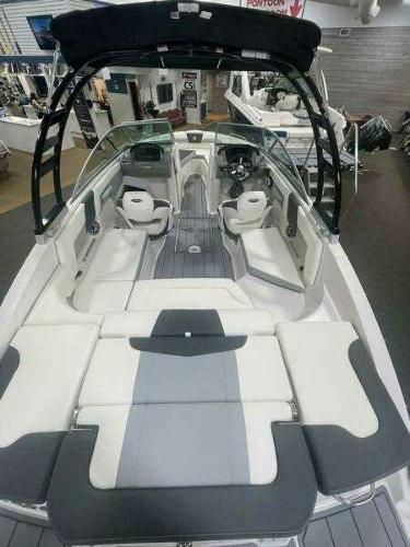 2022 Chaparral 23 Surf boat with spacious seating and sleek design in showroom.