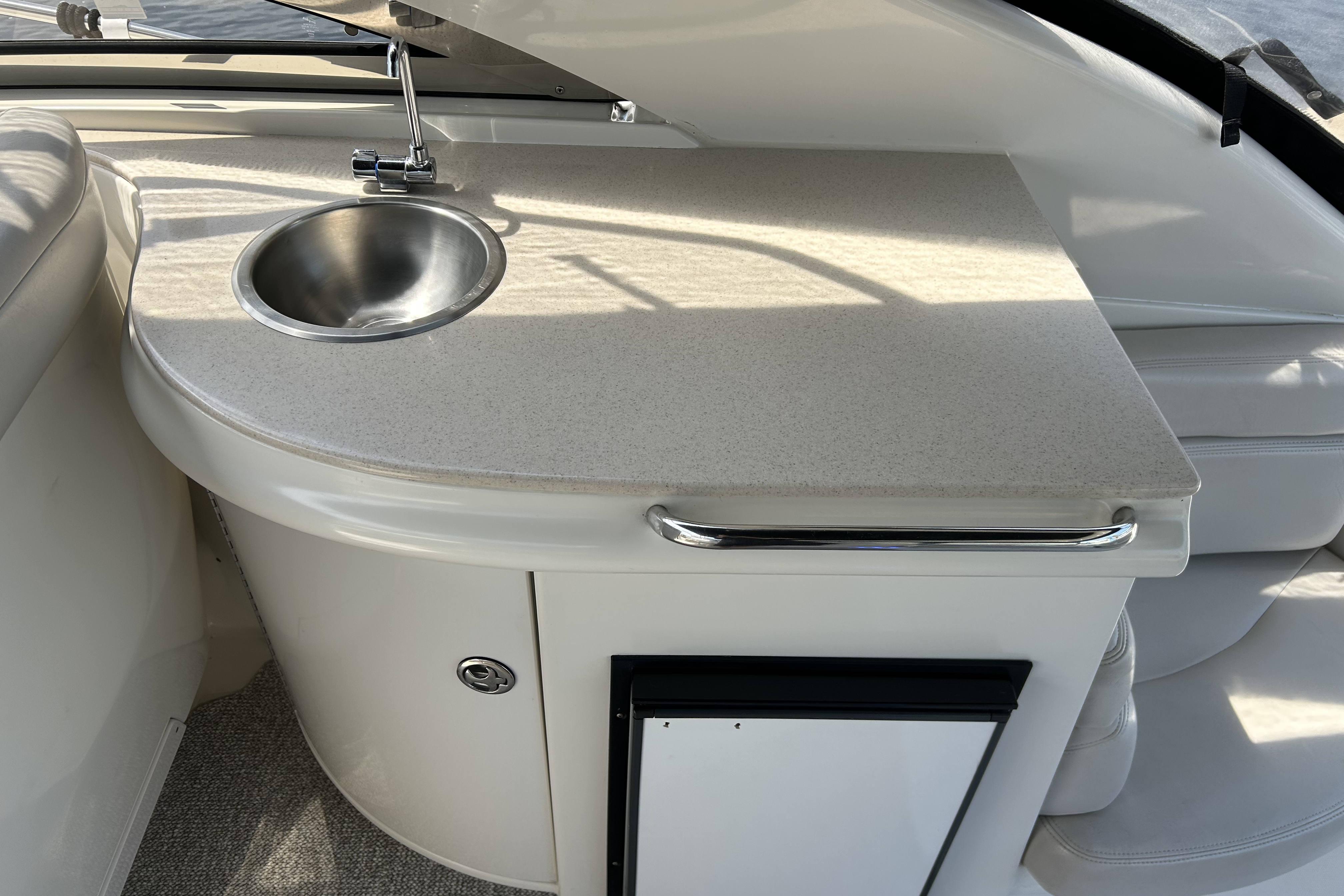 Compact kitchenette with sink on 2002 Regal Commodore 4260 yacht.
