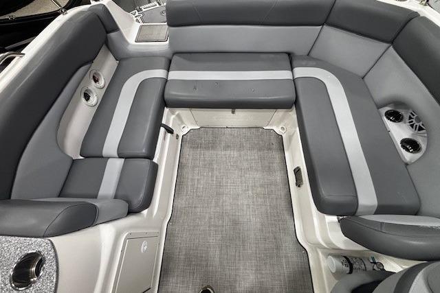 2023 NauticStar 243DC Sport Deck interior with gray seating and carpeted floor.