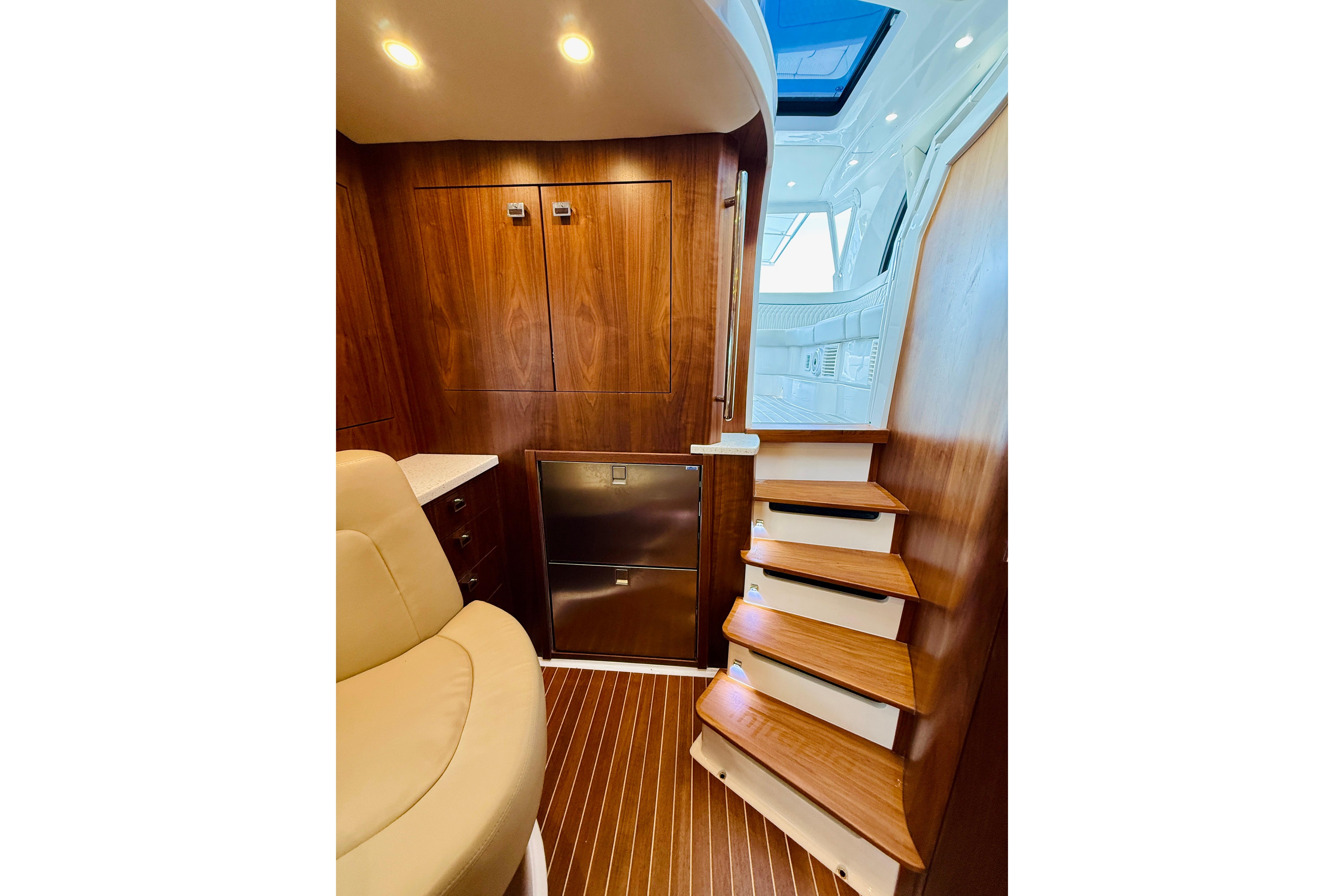 Luxurious interior of 2021 Intrepid 410 Evolution yacht with wooden stairs and seating.