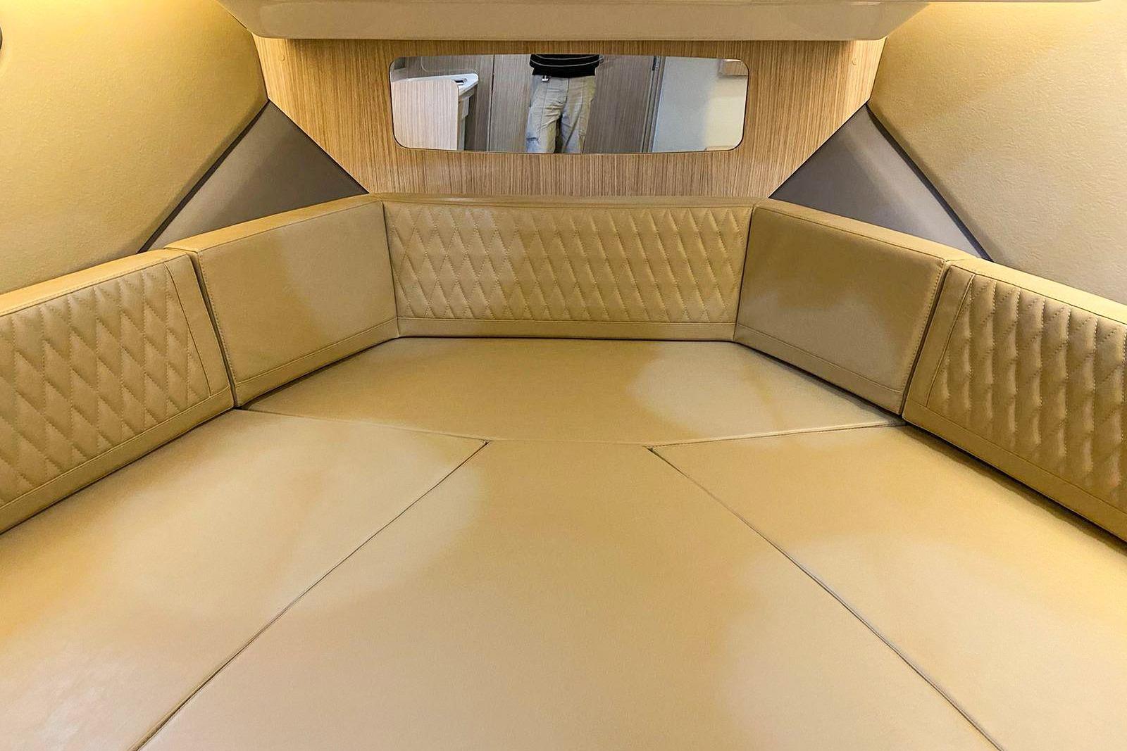 Luxurious interior of 2027 Hanover 387 boat with beige leather seating and wood accents.