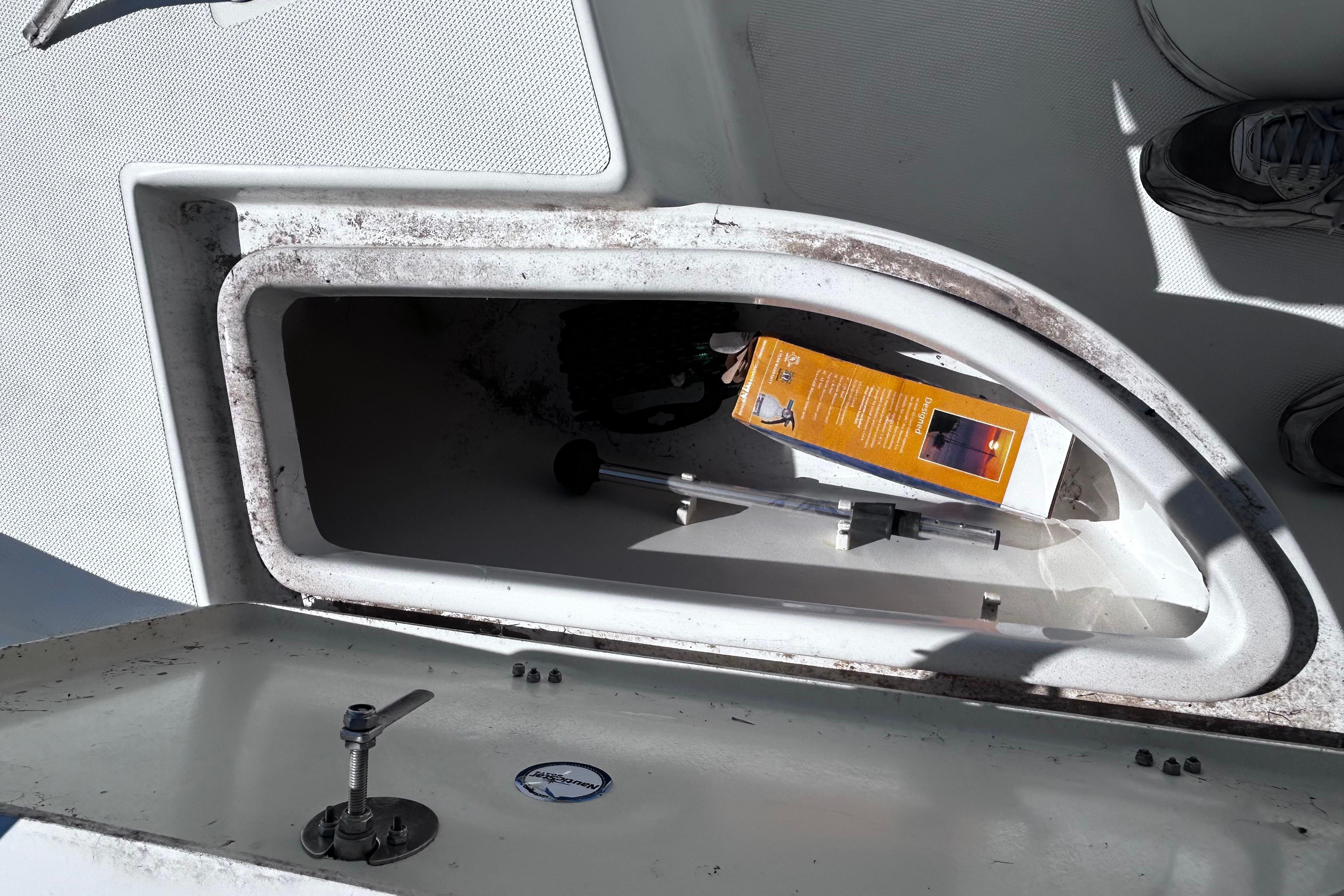 Open storage compartment on 2016 NauticStar 1810 NauticBay boat with items inside.