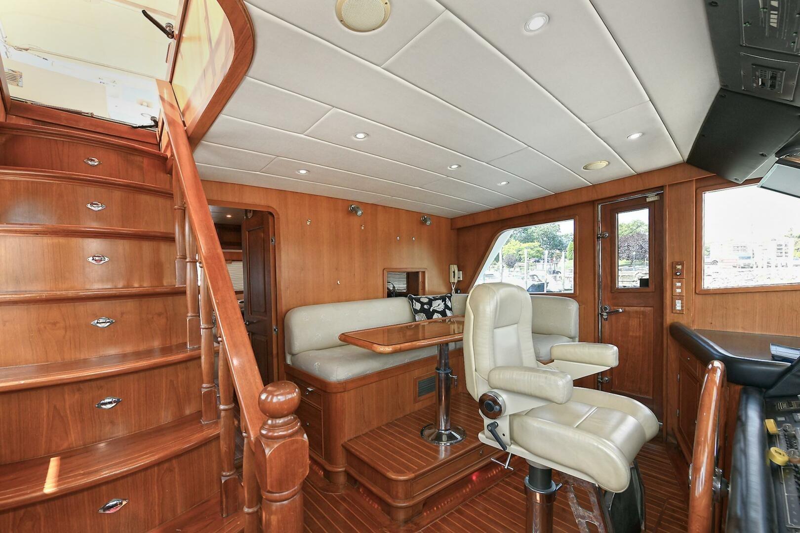 Luxurious 2002 Grand Alaskan Flushdeck yacht interior with elegant wood finishes and seating.