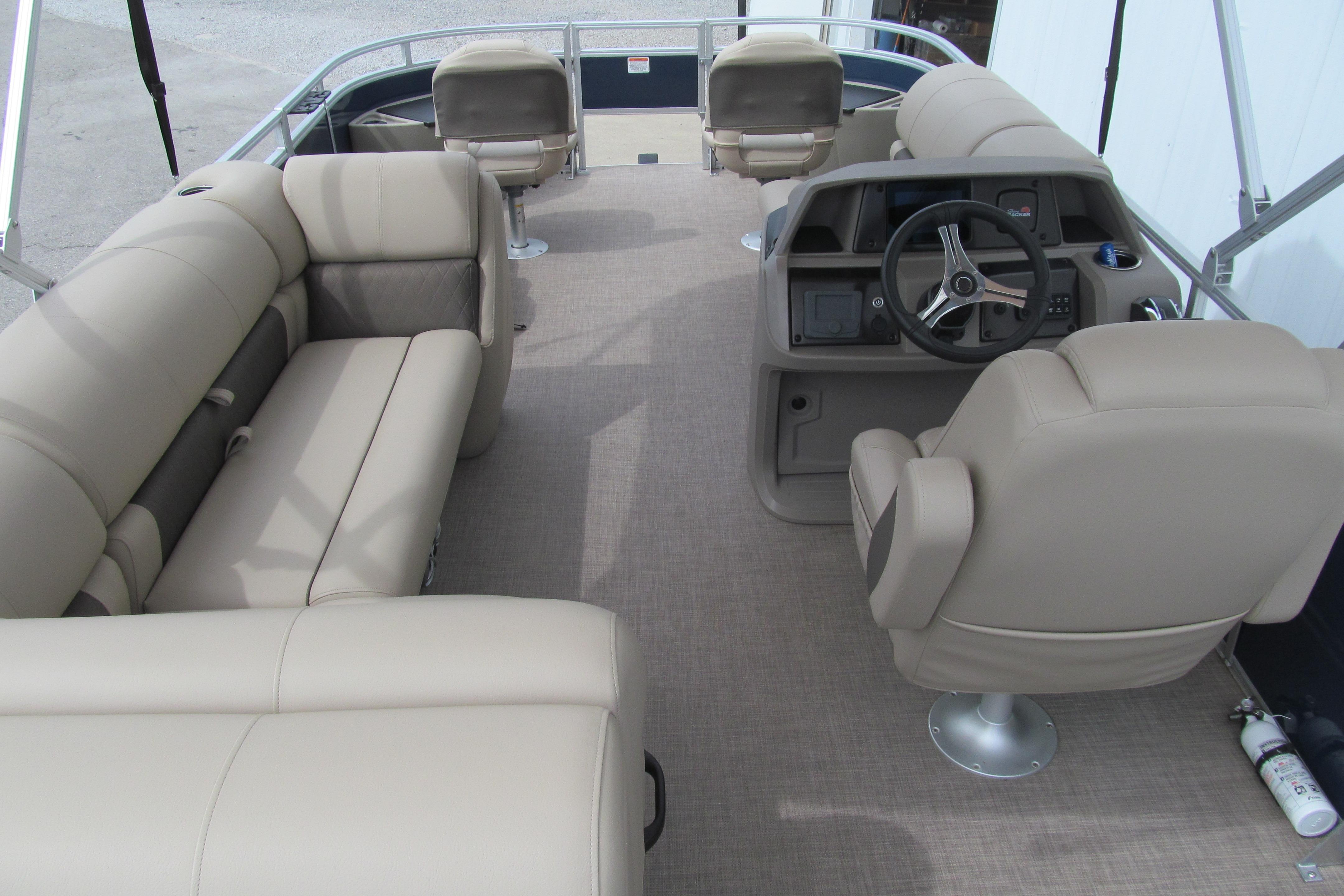 2024 Sun Tracker Fishin' Barge 20 DLX interior with beige seating and steering console.