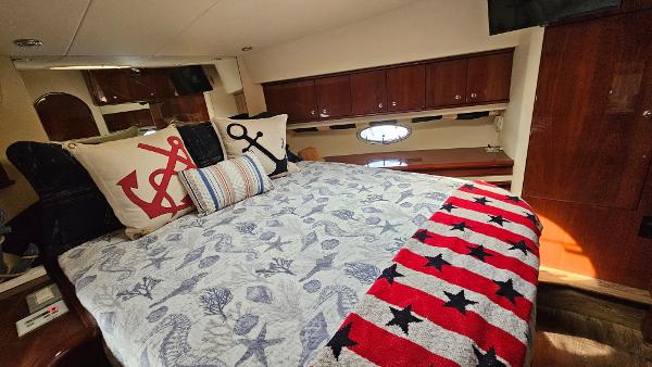 Luxurious bedroom in 2005 Neptunus 56 Flybridge yacht with nautical-themed decor.