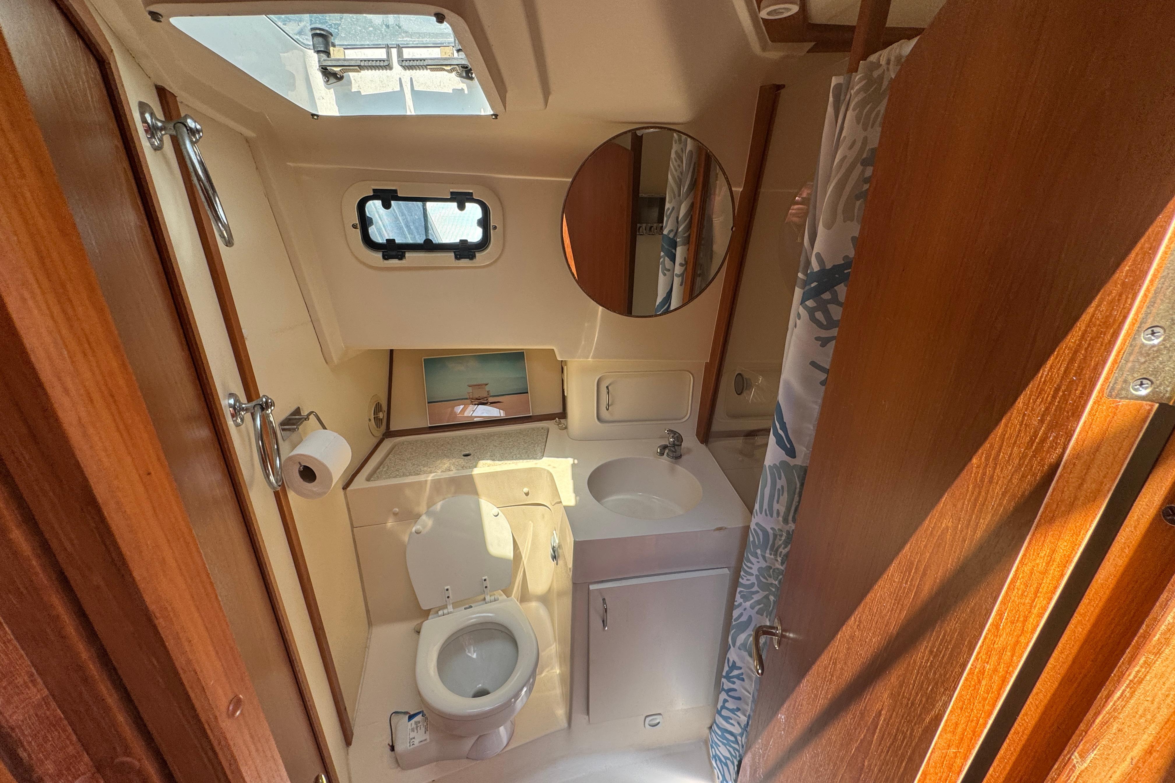 Bathroom interior of 2002 Mainship 390 Trawler with toilet, sink, and shower.