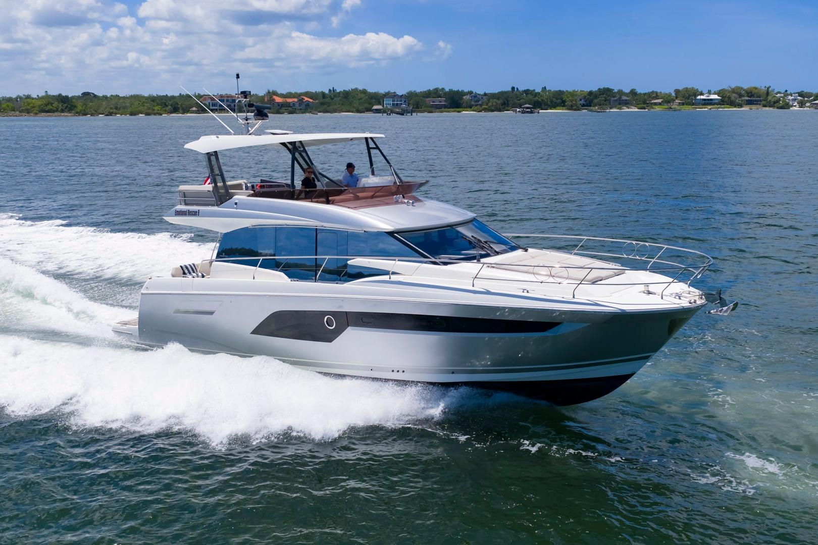 Luxury 2022 Prestige 520 yacht cruising on open water under a clear sky.