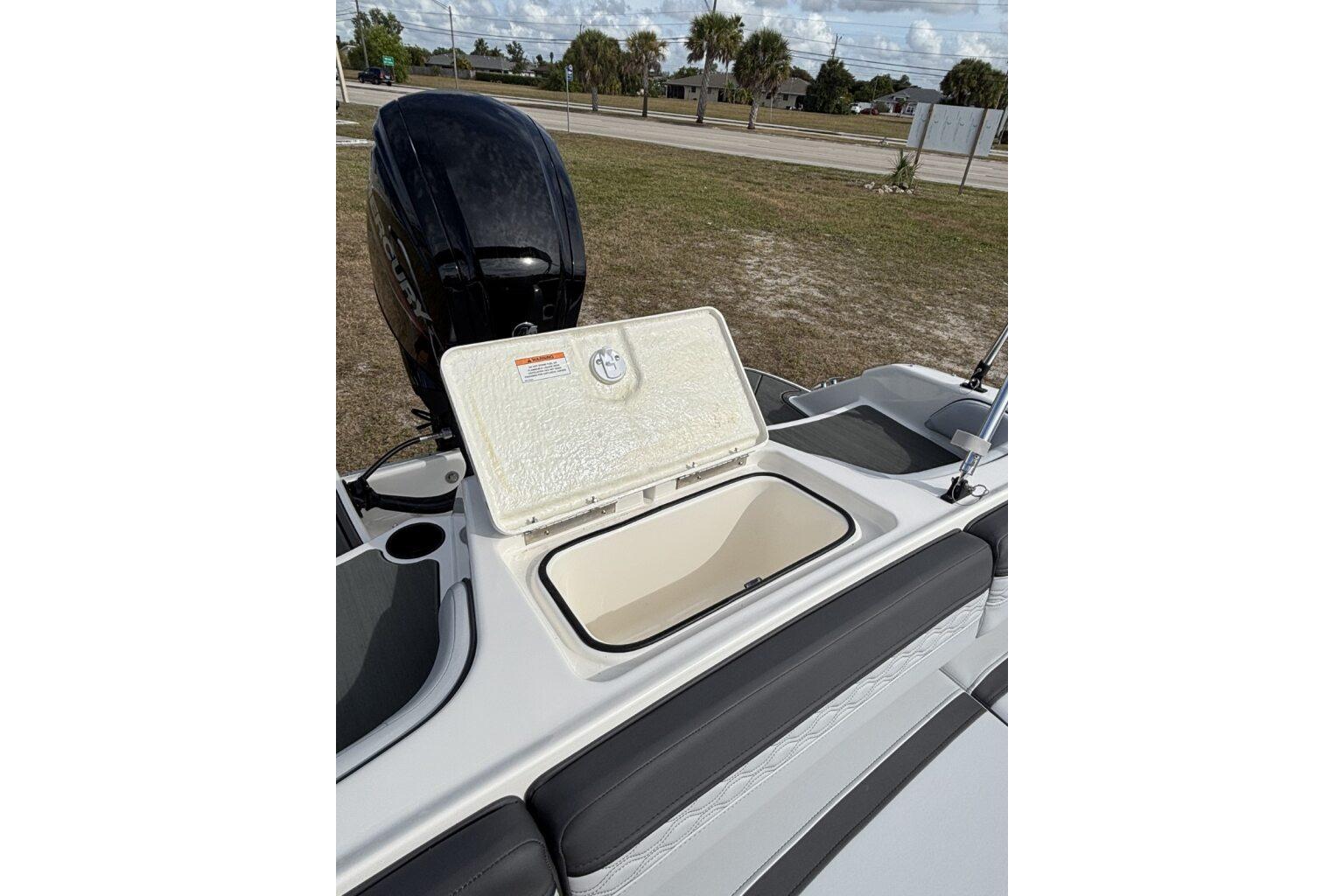 2025 Bayliner Element M17 boat with open storage compartment and outboard motor.