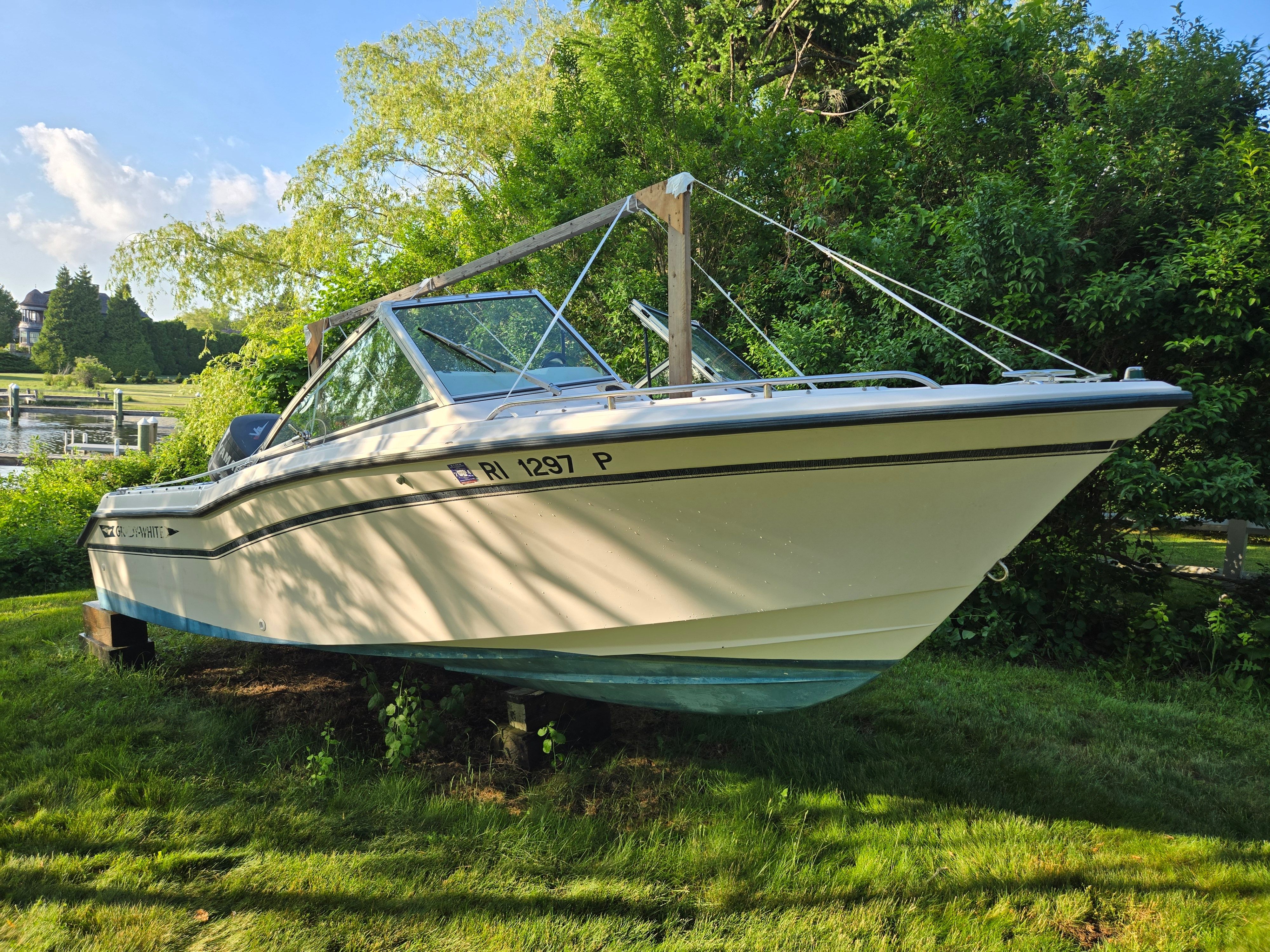 A 1994 Grady-White Tournament 192 boat is on a lawn, surrounded by trees.