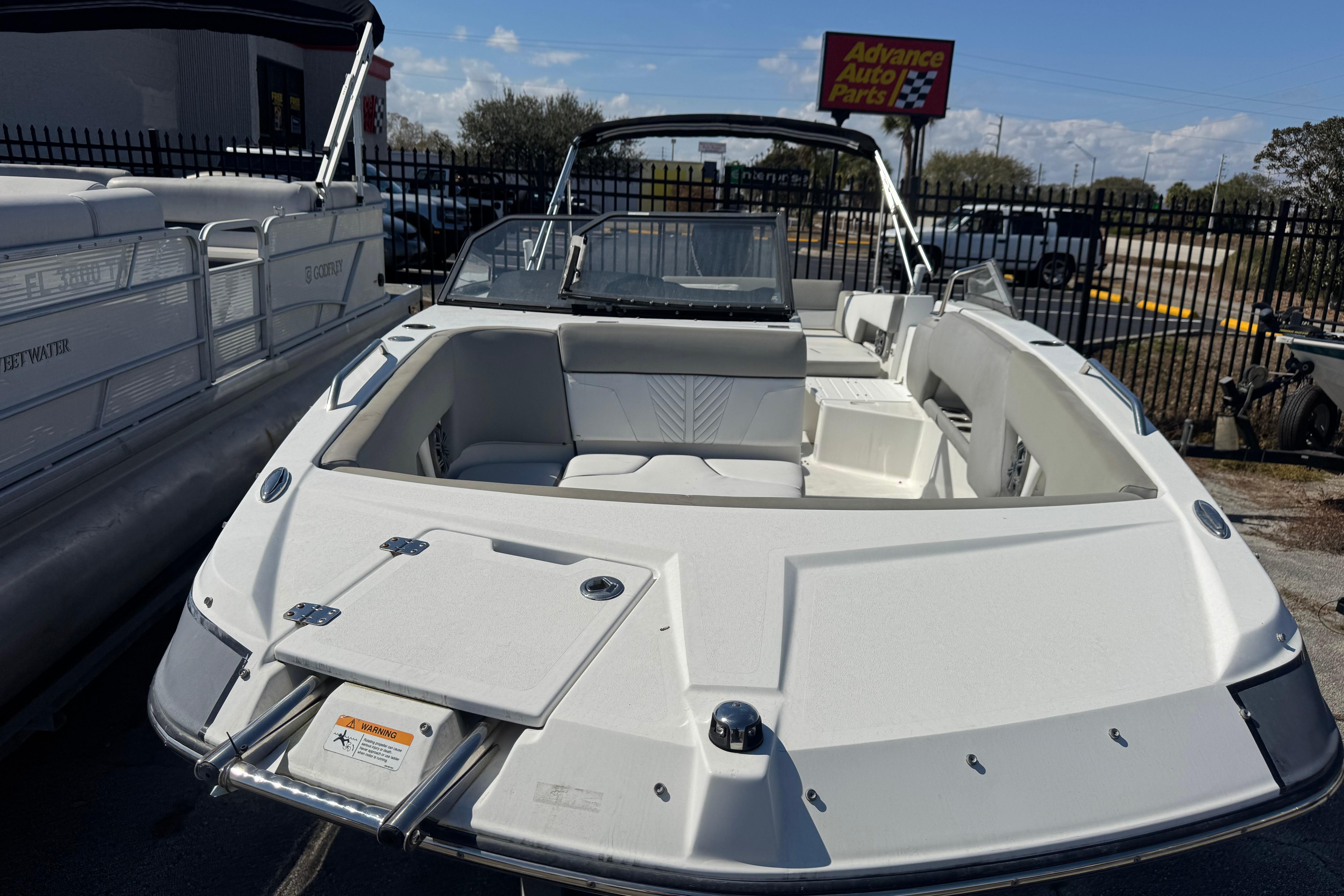 2020 Glastron GTD 240 boat displayed outdoors near auto parts store.