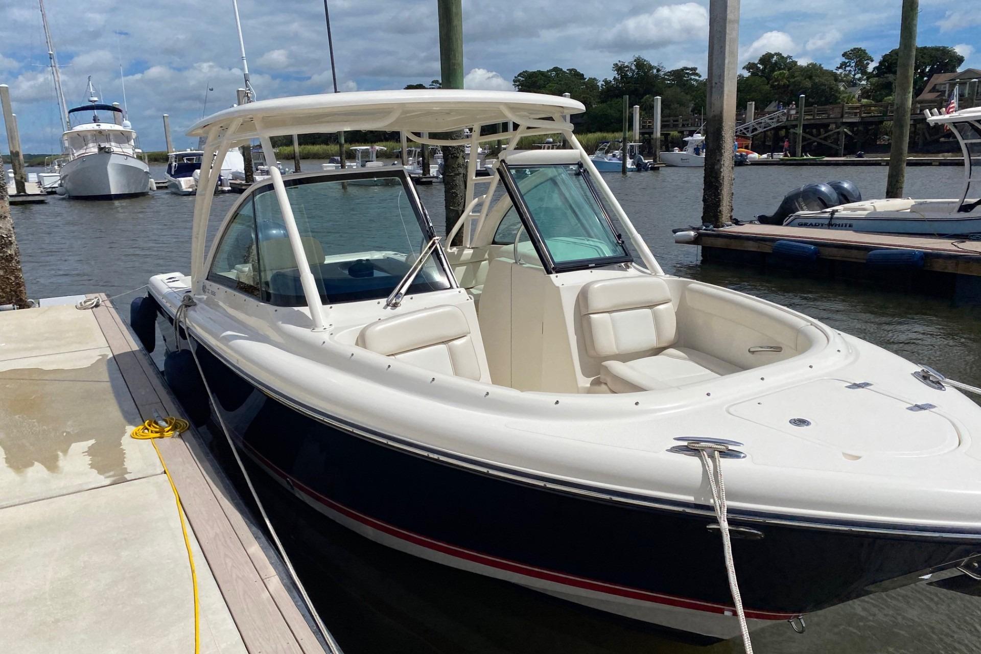 2013 Pursuit DC 265 Dual Console boat docked at marina under cloudy sky.