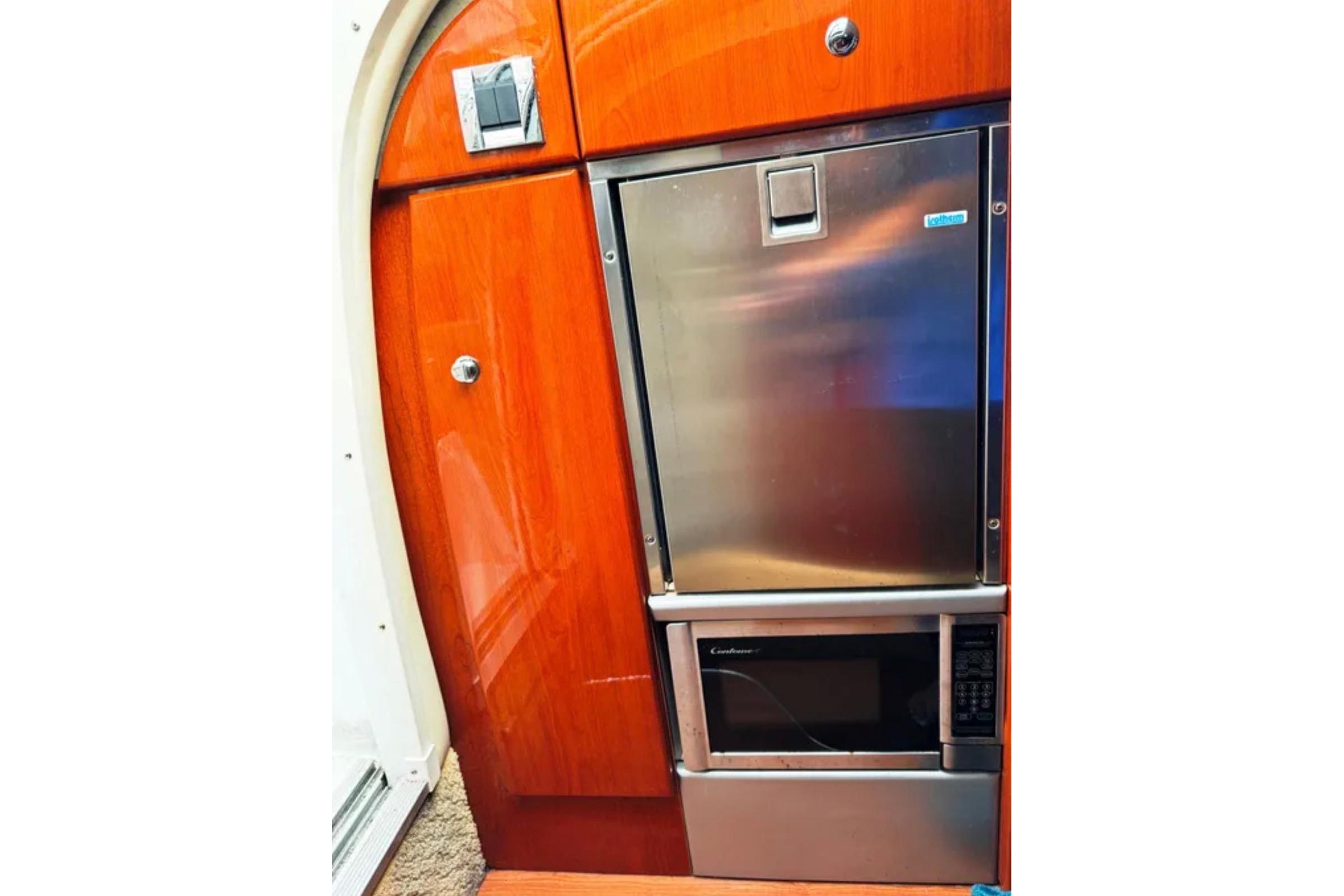 2010 Formula 310 Sun Sport interior with stainless steel fridge and microwave.