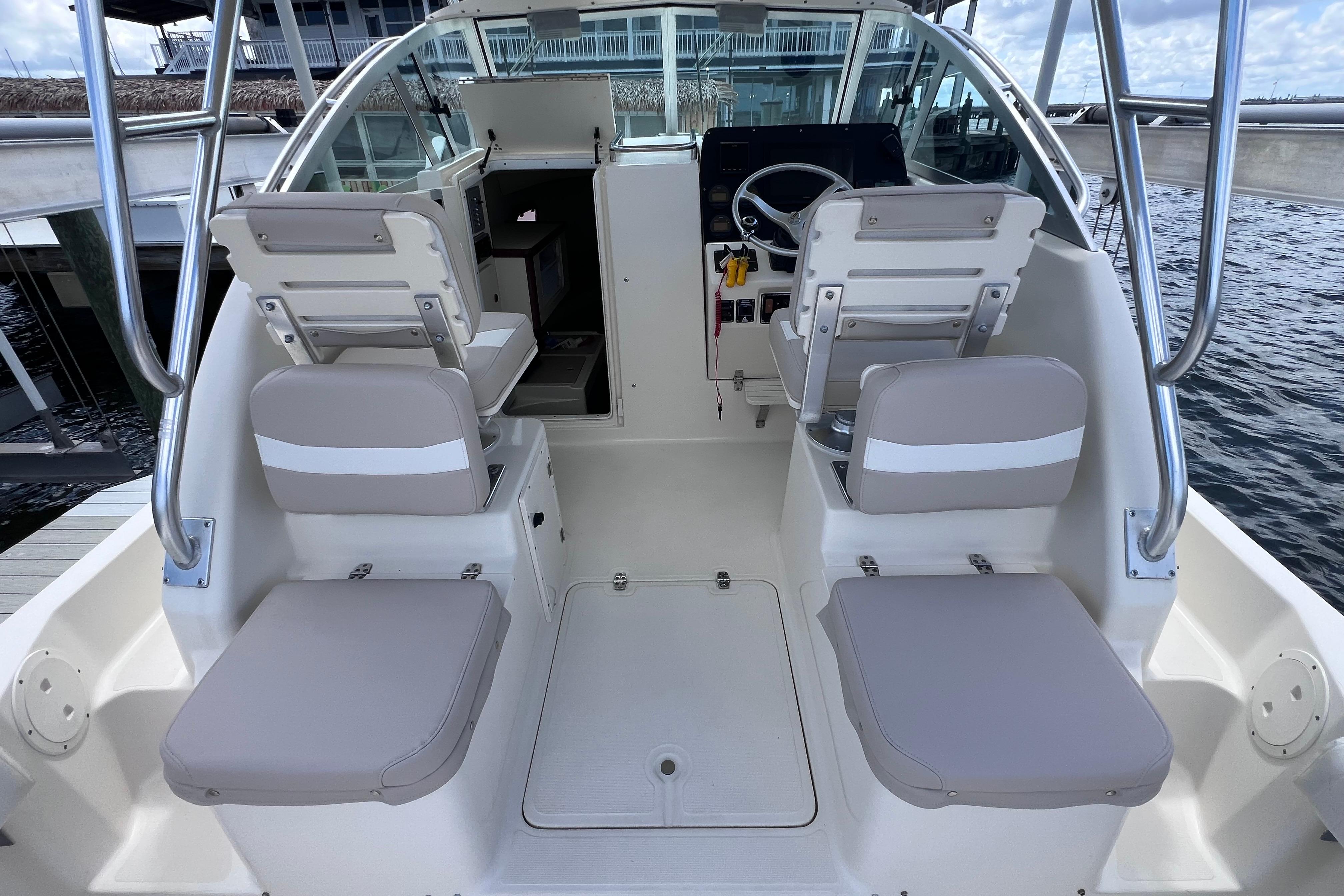 2004 Pursuit 2870 Walkaround boat interior with seating and steering wheel, docked by water.