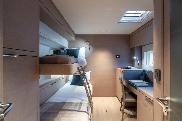 Luxurious cabin interior of 2025 Lagoon SIXTY 5 yacht with bunk beds and desk.