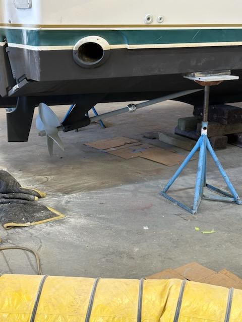 Pursuit 3400 Express 2000 boat on stands, showing propeller and hull details.