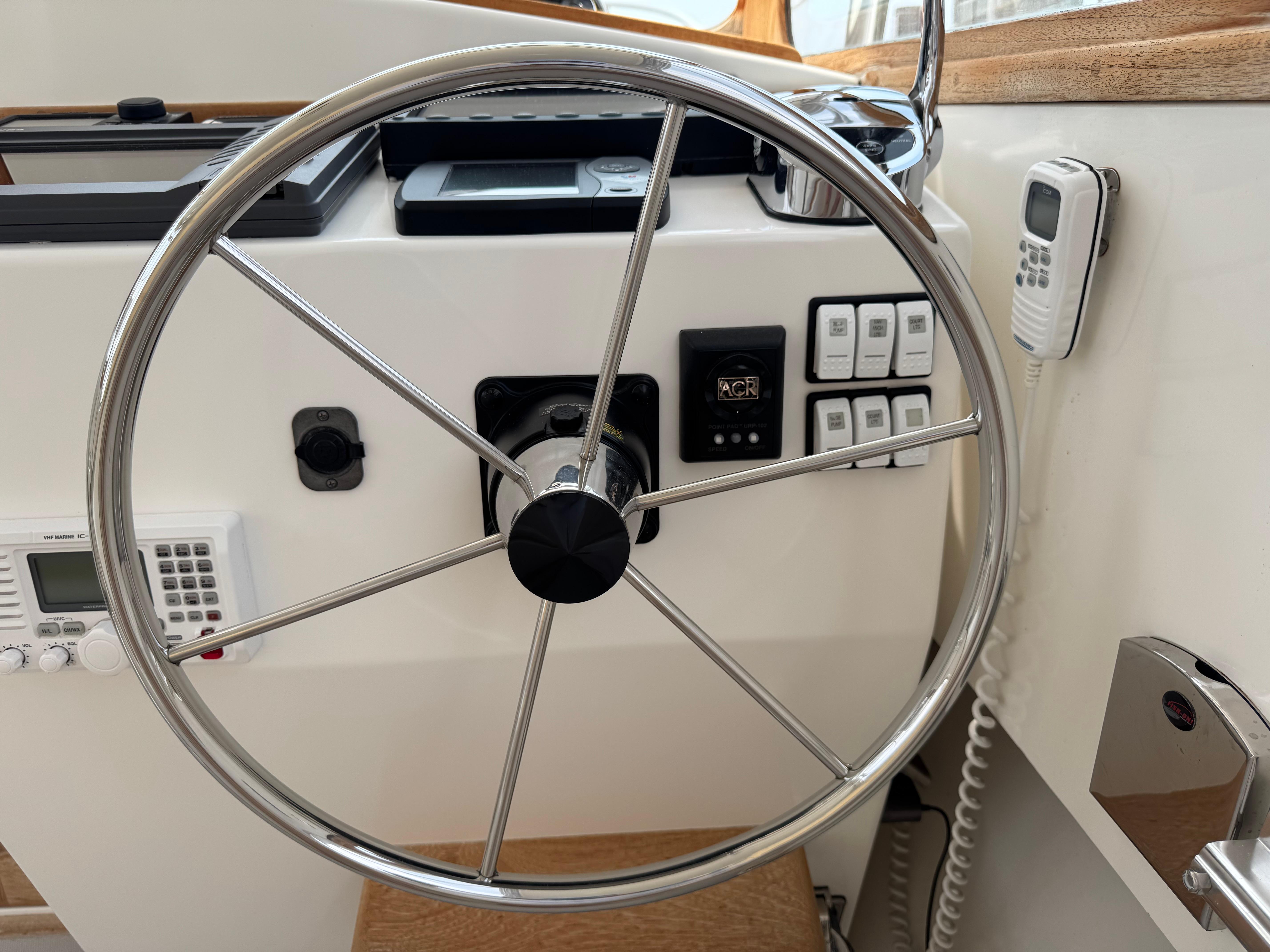 Steering wheel and controls of a 2006 Fortier 26 boat cockpit.