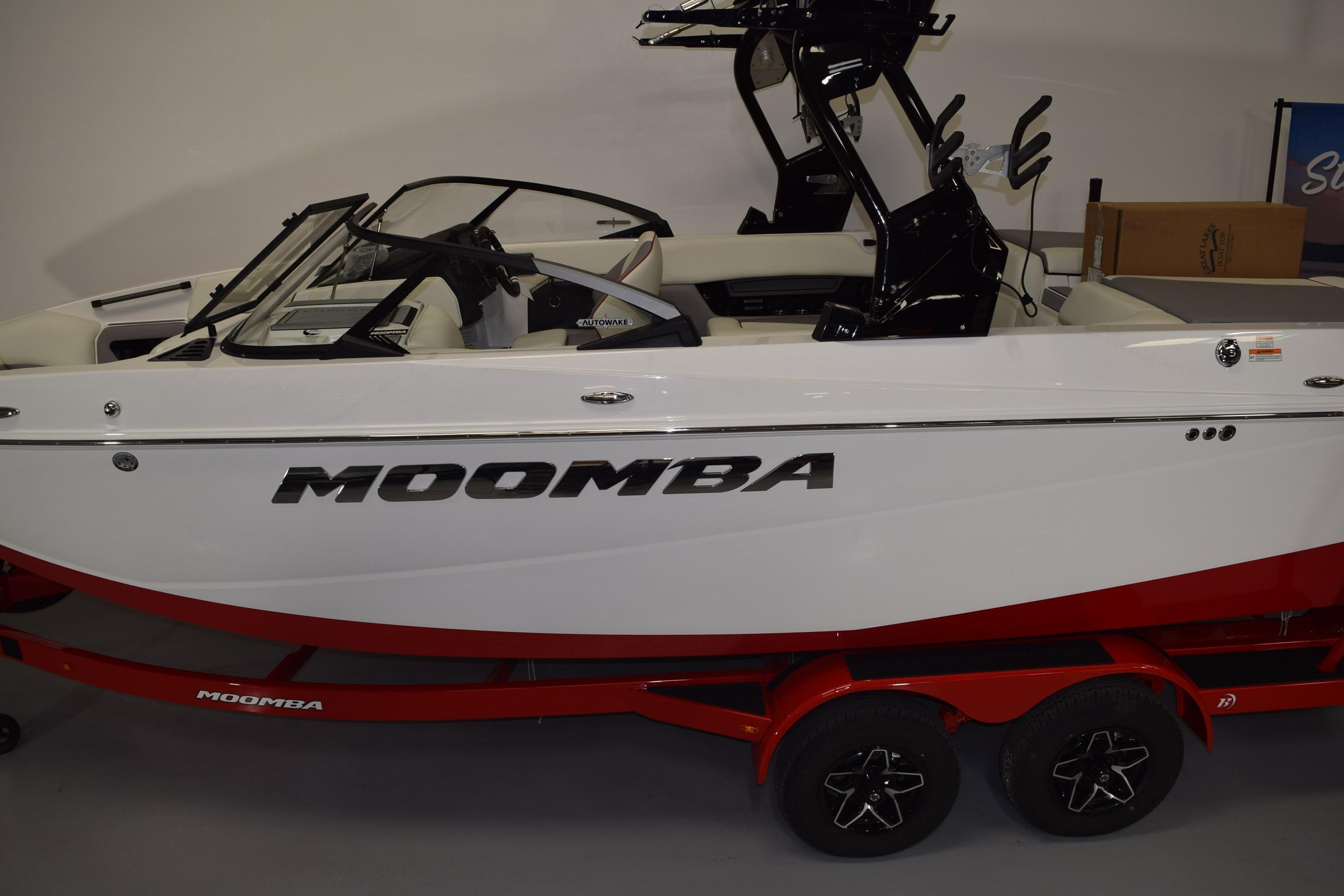 2026 Moomba Craz boat with red trailer, side view in showroom.