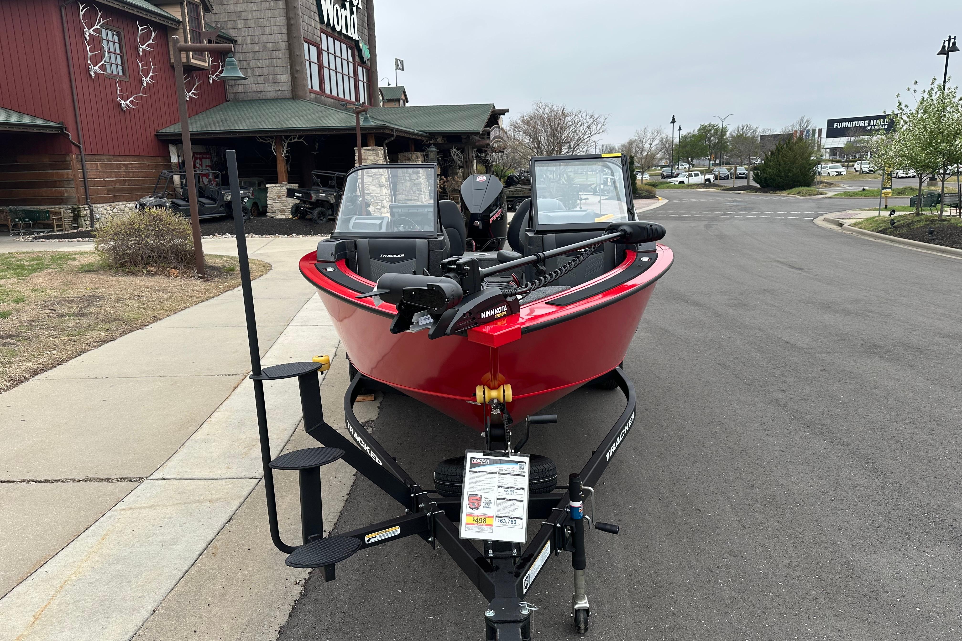 2026 Tracker Targa V-19 Combo boat in red, parked outside a store.