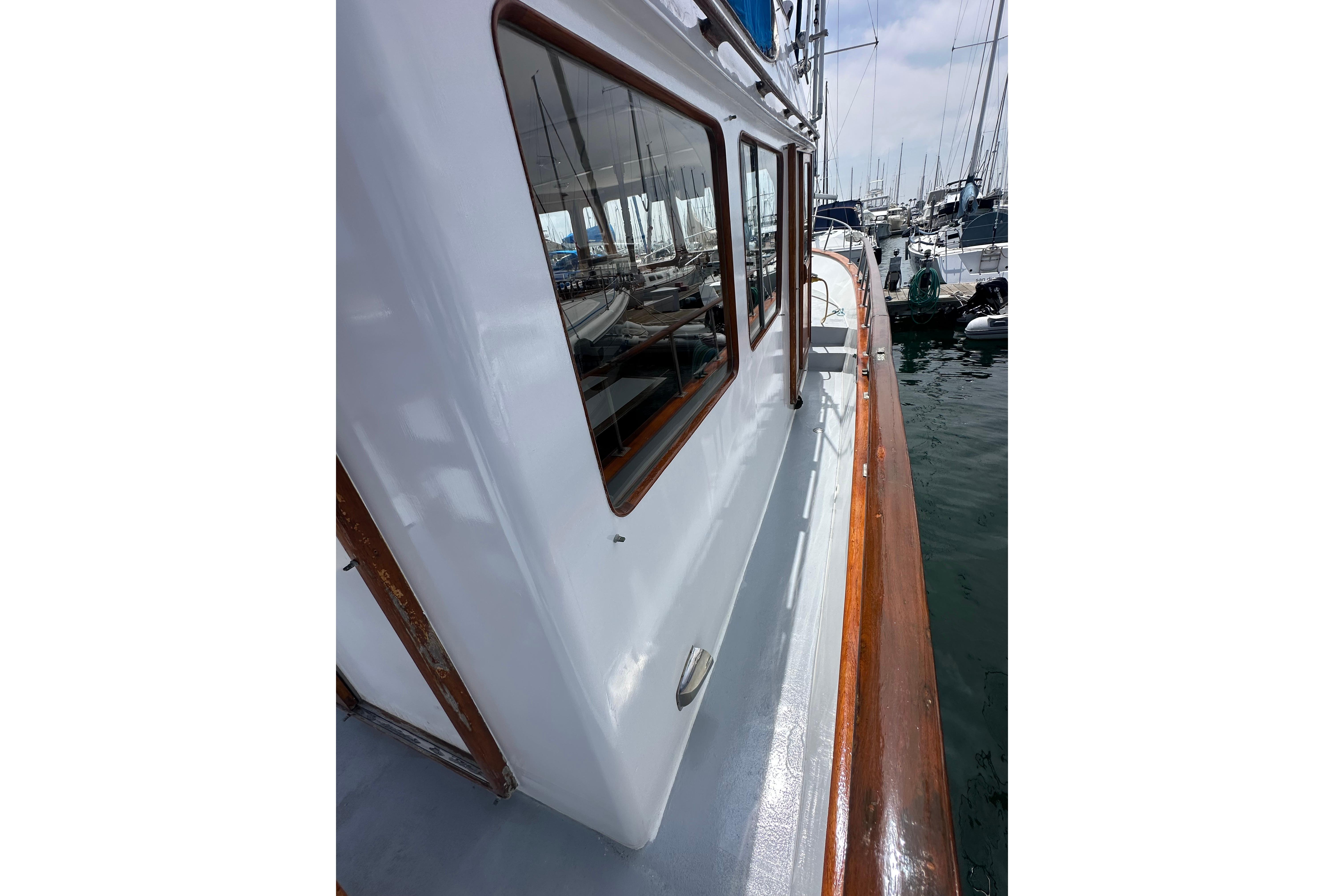 1973 CHB 33 boat docked, showcasing sleek white exterior and wooden trim.