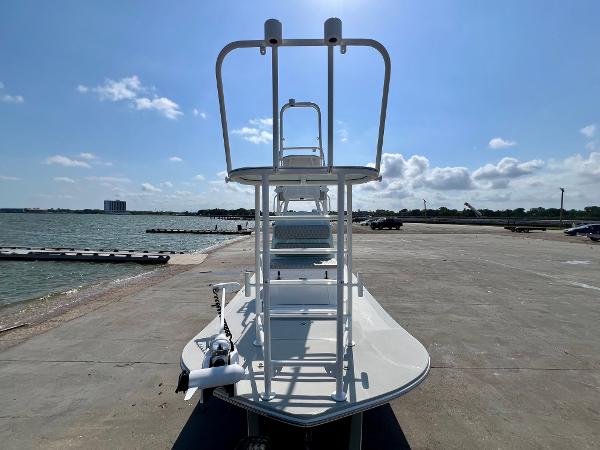 2022 Shallow Sport 20 Classic boat docked by the waterfront under a clear blue sky.
