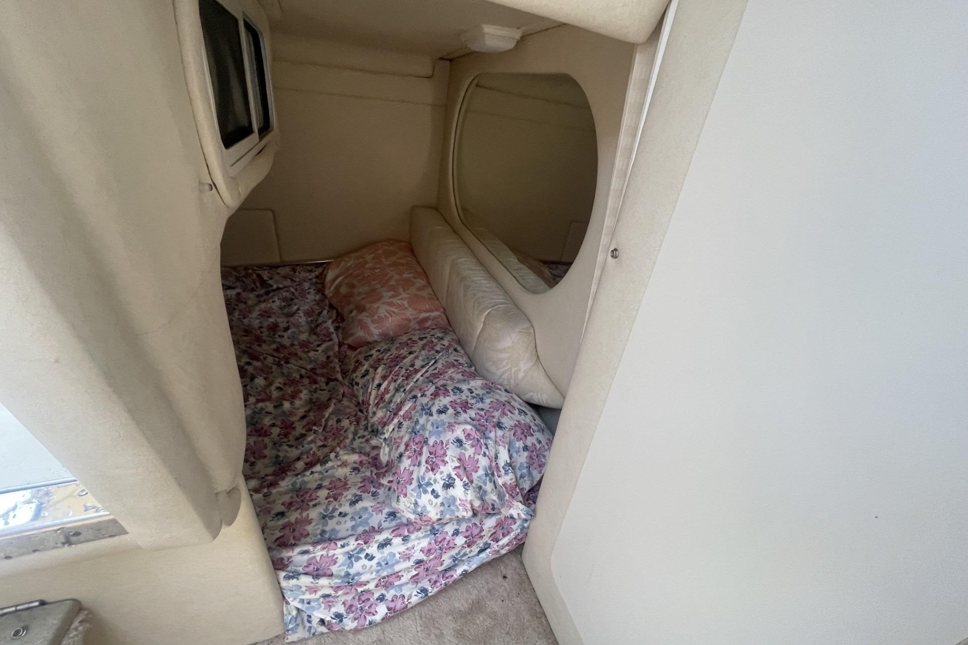 Cozy cabin interior of 2000 Sea Ray Sundancer 260 with floral bedding.