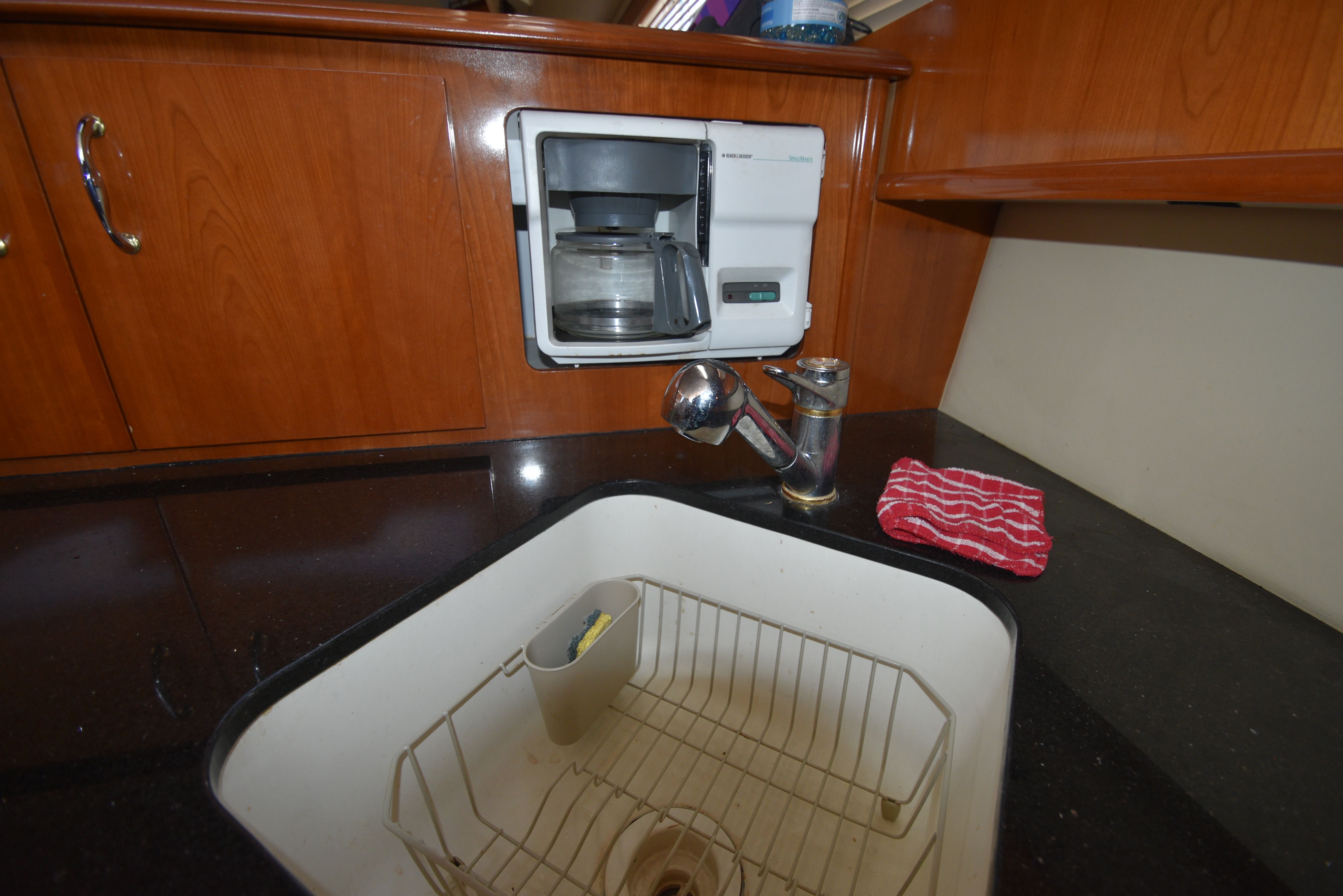 The yacht's kitchen features a sink, faucet, and coffee maker.
