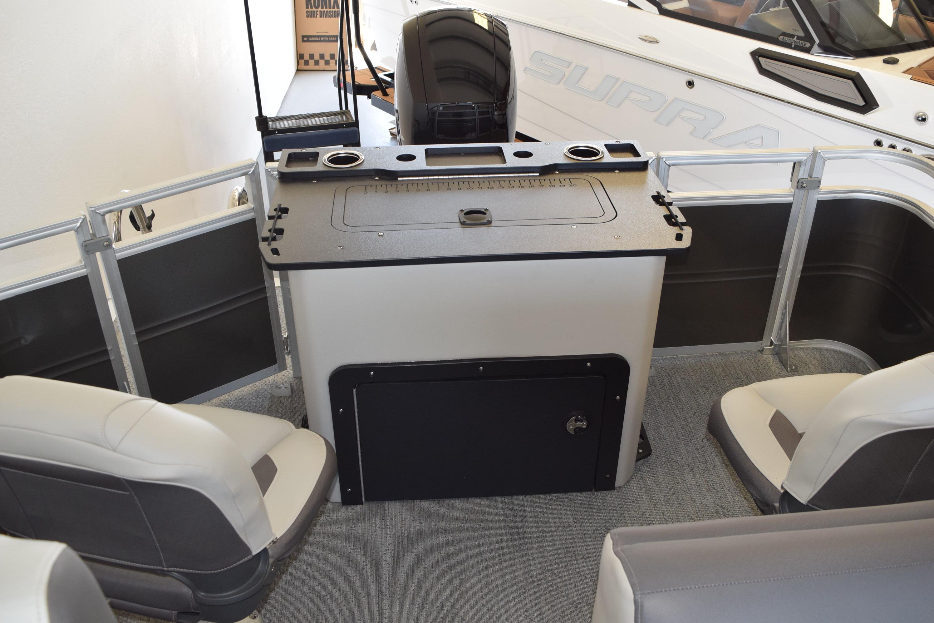 2026 Sun Tracker Fishin' Barge 22 DLX interior with seating and fishing station.