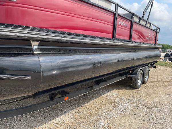 2023 Regency 250DL3 pontoon boat with red and black design on a trailer.