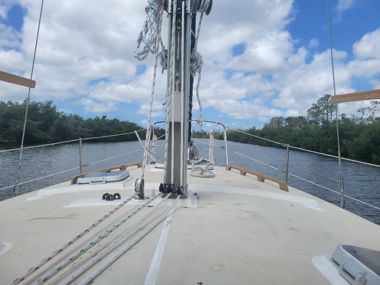 The deck of a 1989 Cape Dory MS300 on a calm river with a cloudy sky.